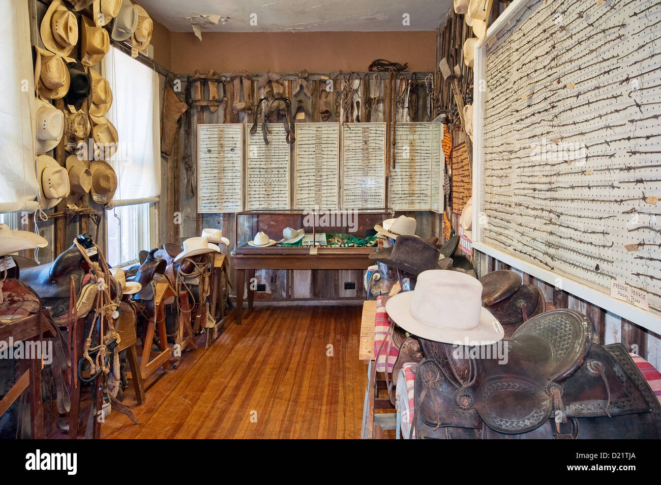 Muestras de alambre de púas, sombreros de vaqueros, monturas en Rodeo y marcas en la habitación al oeste del Museo de Pecos en Pecos, Texas, EE.UU. Foto de stock