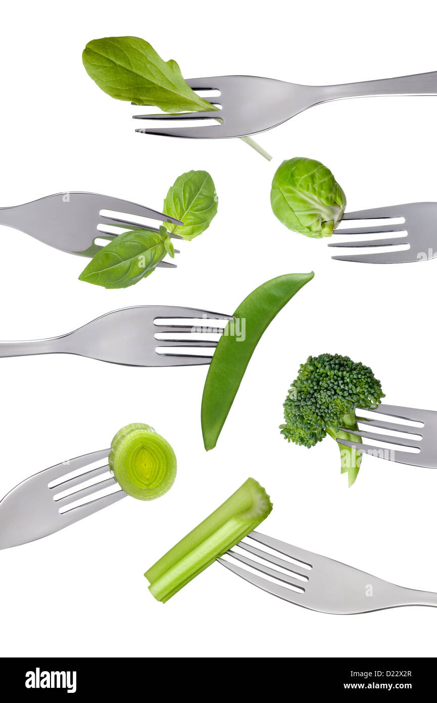 Variedad de verde fresco verduras saludables en las horquillas aislado sobre un fondo blanco. Foto de stock
