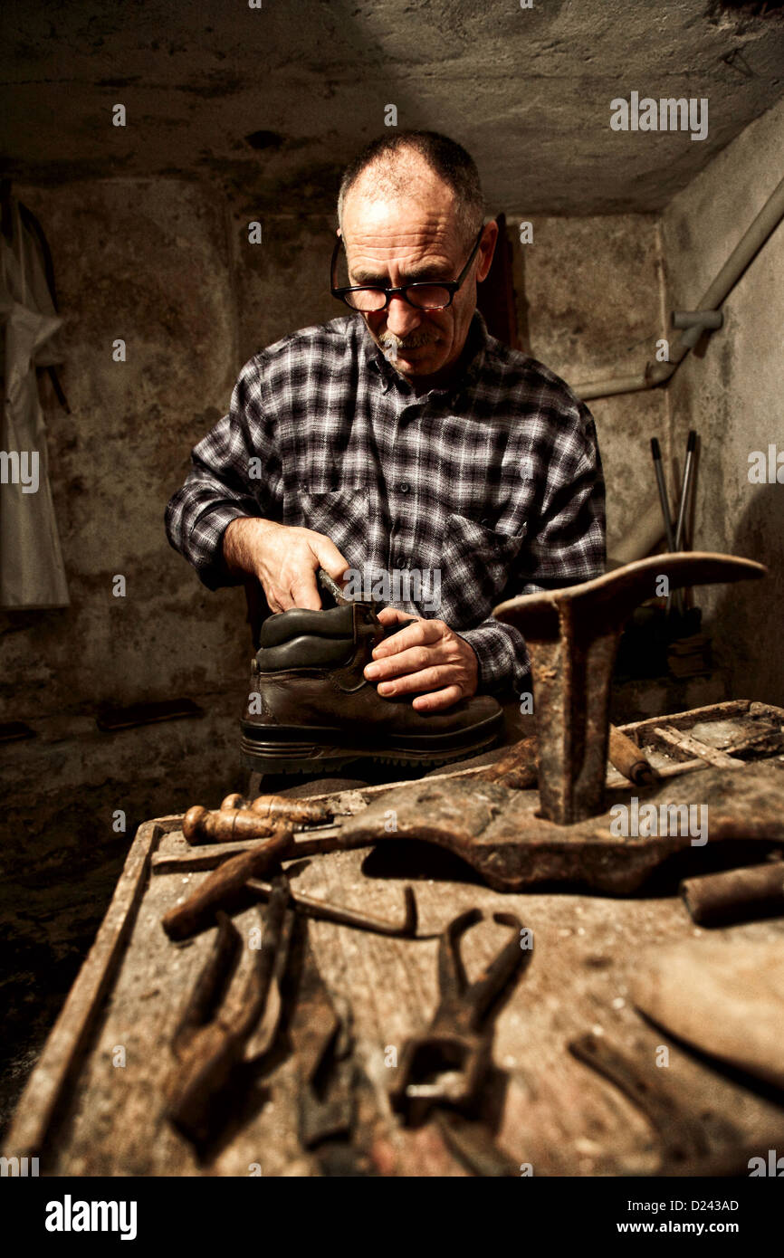 Zapatero en el trabajo con herramientas antiguas Fotografía de stock - Alamy