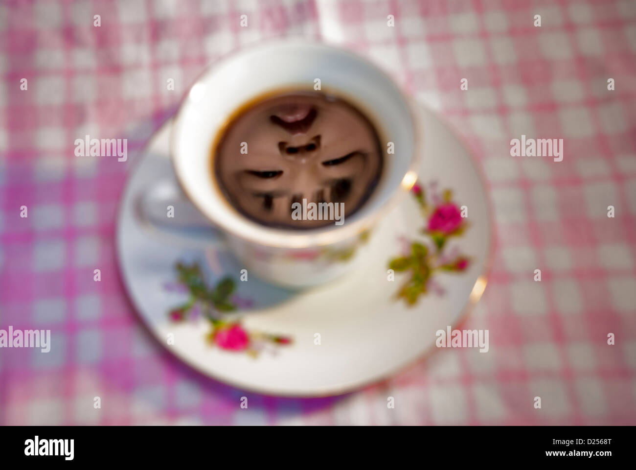 Taza de café negro con el reflejo de un rostro humano Foto de stock