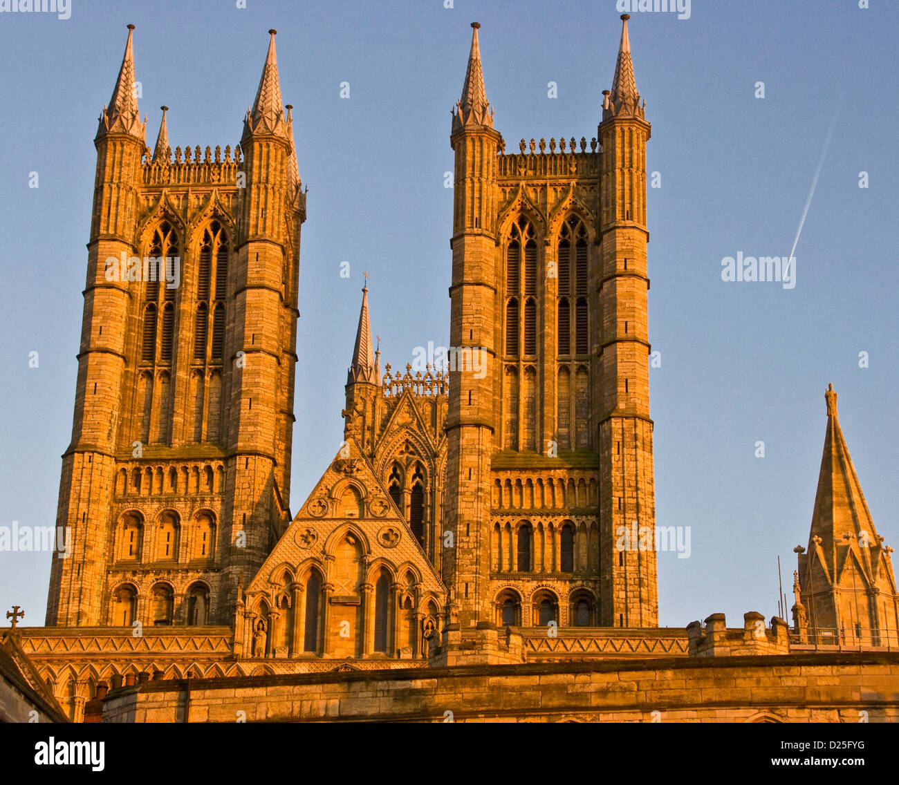Listado como grado 1, la Catedral de Lincoln west front y torres iluminarse en color naranja en el crepúsculo del atardecer Europa Inglaterra Lincolnshire Foto de stock