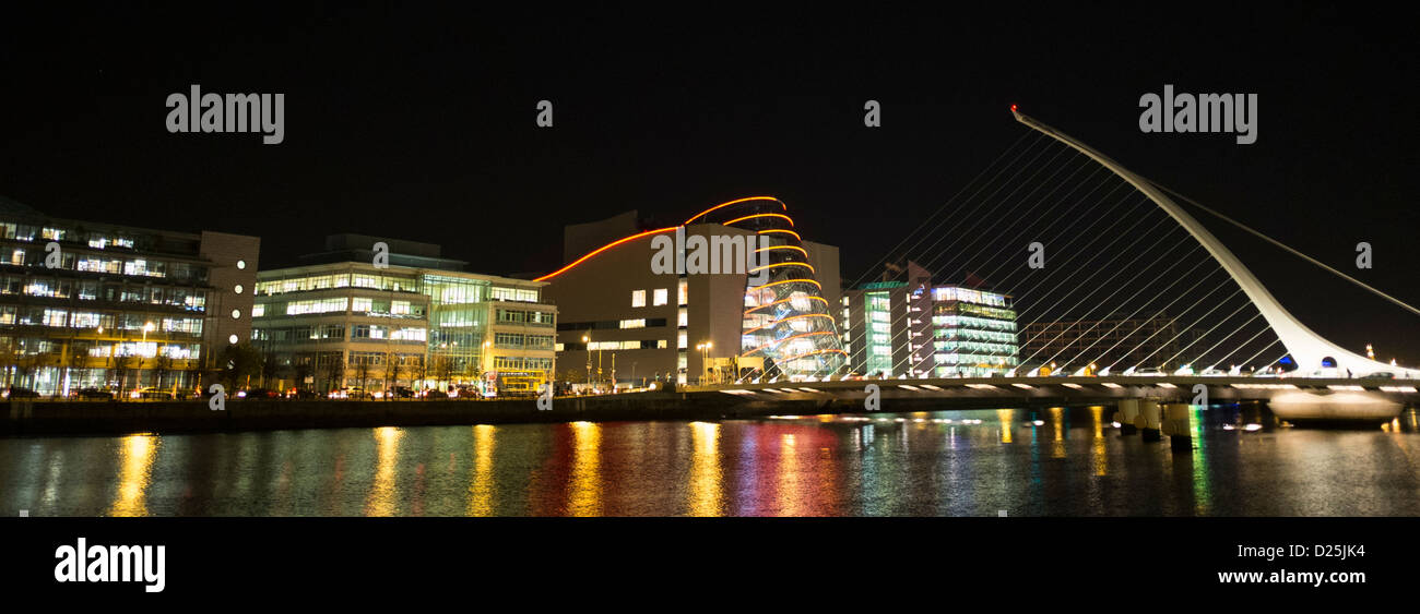 El Centro de Convenciones de Dublín y Samuel Beckett, puente sobre el río Liffey, iluminado por la noche Foto de stock