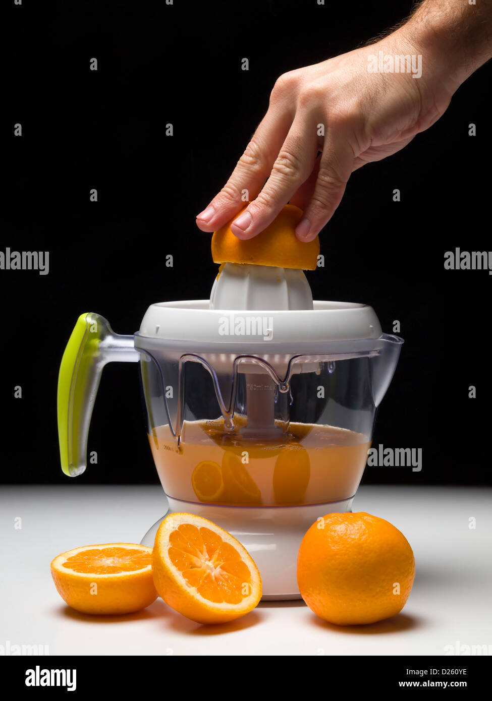 Persona haciendo zumo de naranja con exprimir la máquina Fotografía de  stock - Alamy