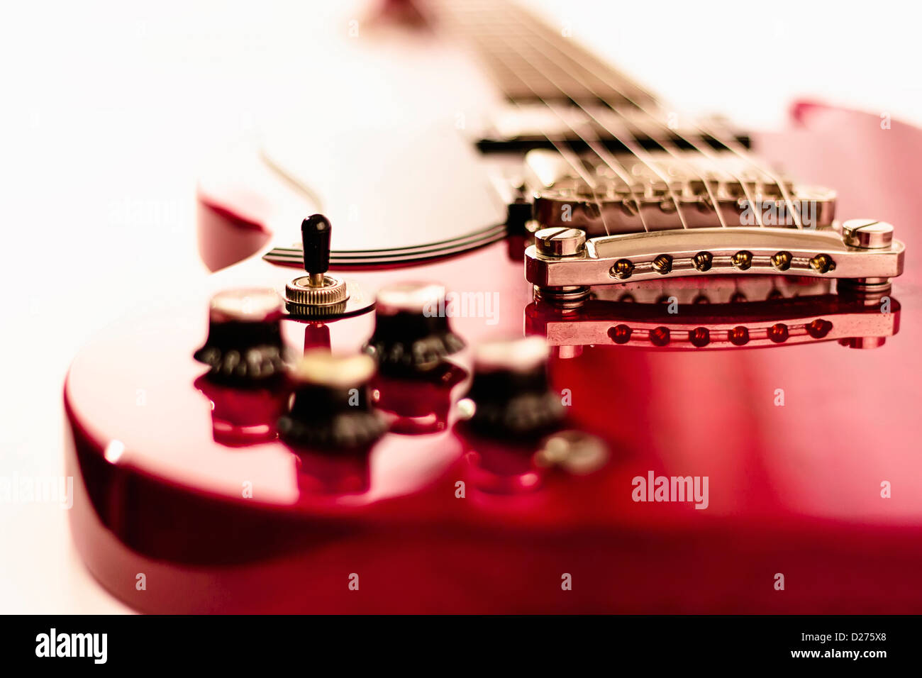 Guitarra eléctrica roja sobre fondo blanco agradable con profundidad de campo. Foto de stock