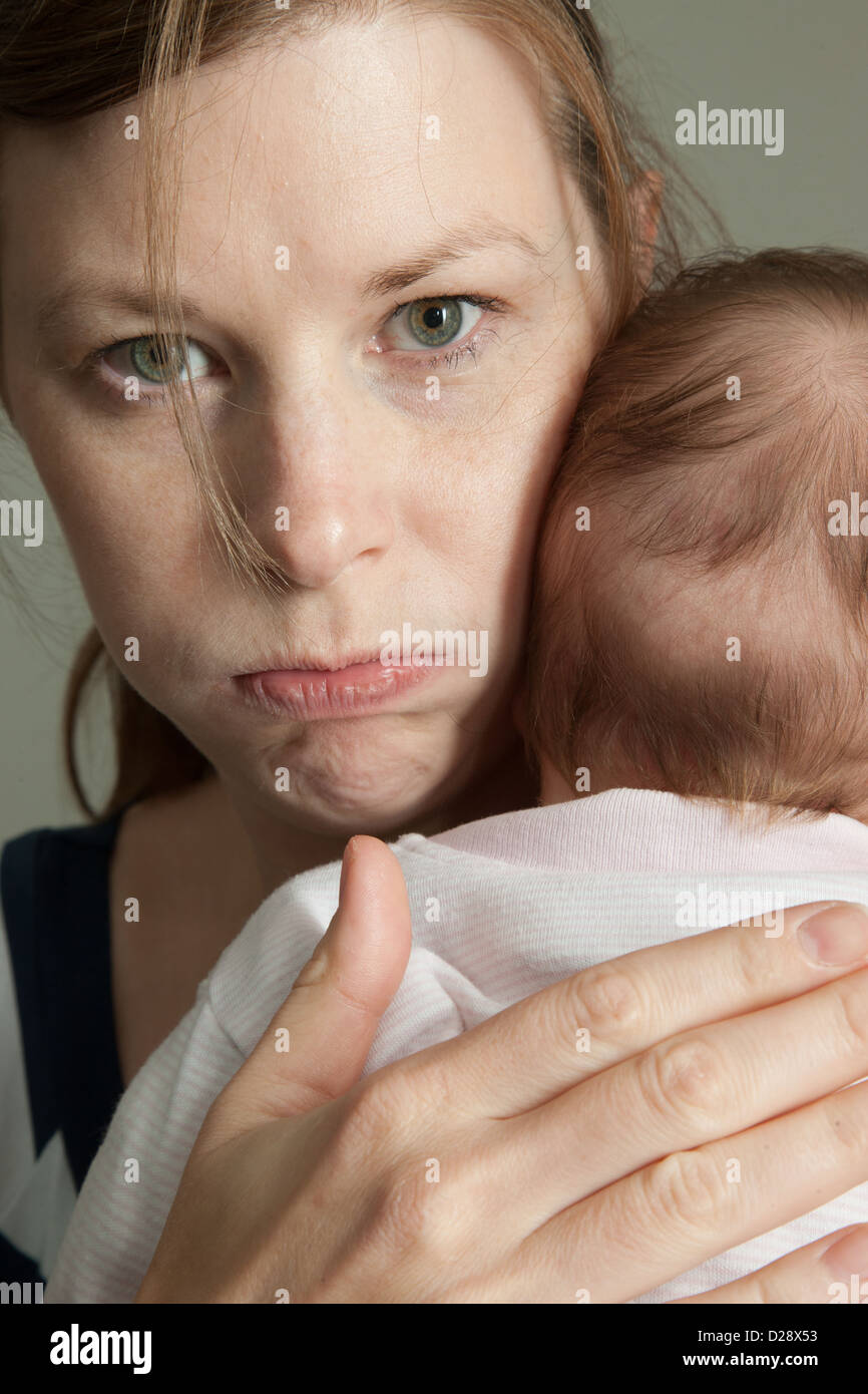 Enojado madre sosteniendo bebé Foto de stock