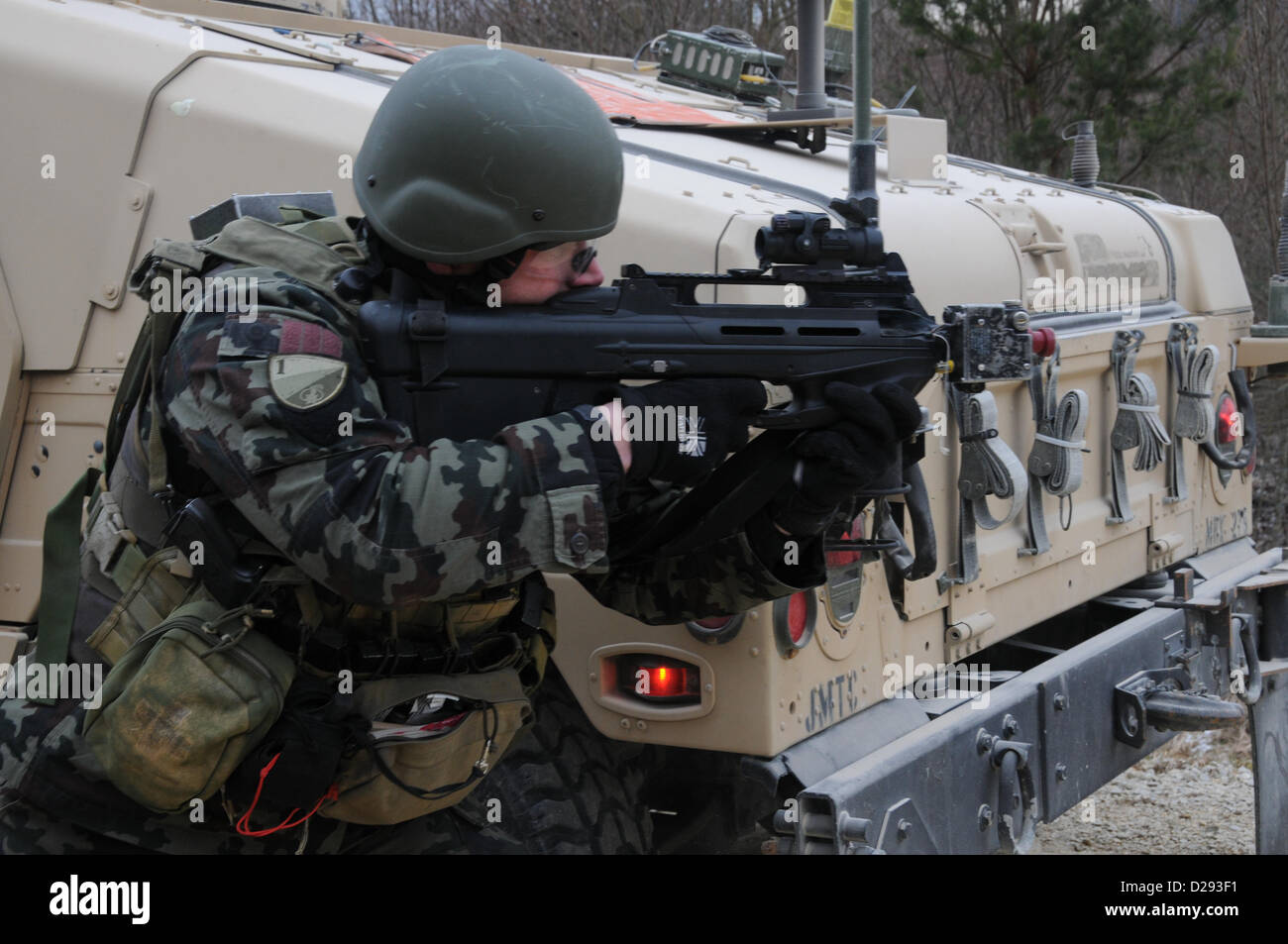 Hohenfels, Alemania, 17 de enero de 2013. Un soldado del ejército esloveno de la 1ª Brigada Motorizada tira la seguridad junto a un Humvee durante un equipo de asesores militares (MAT) ejercicios de capacitación en el centro de preparación multinacionales conjuntas en Hohenfels, Alemania, Jan 17, 2013colchonetas y equipos de asesores de policía están diseñados para replicar el entorno operacional en Afganistán mientras se preparan los equipos para operaciones de contrainsurgencia con la capacidad de formar, asesorar y permitir que el Ejército Nacional de Afganistán y de la Policía Nacional de Afganistán. (Ee.Uu. Foto por sargento del ejército. Gemma Iglesias/liberado) Foto de stock