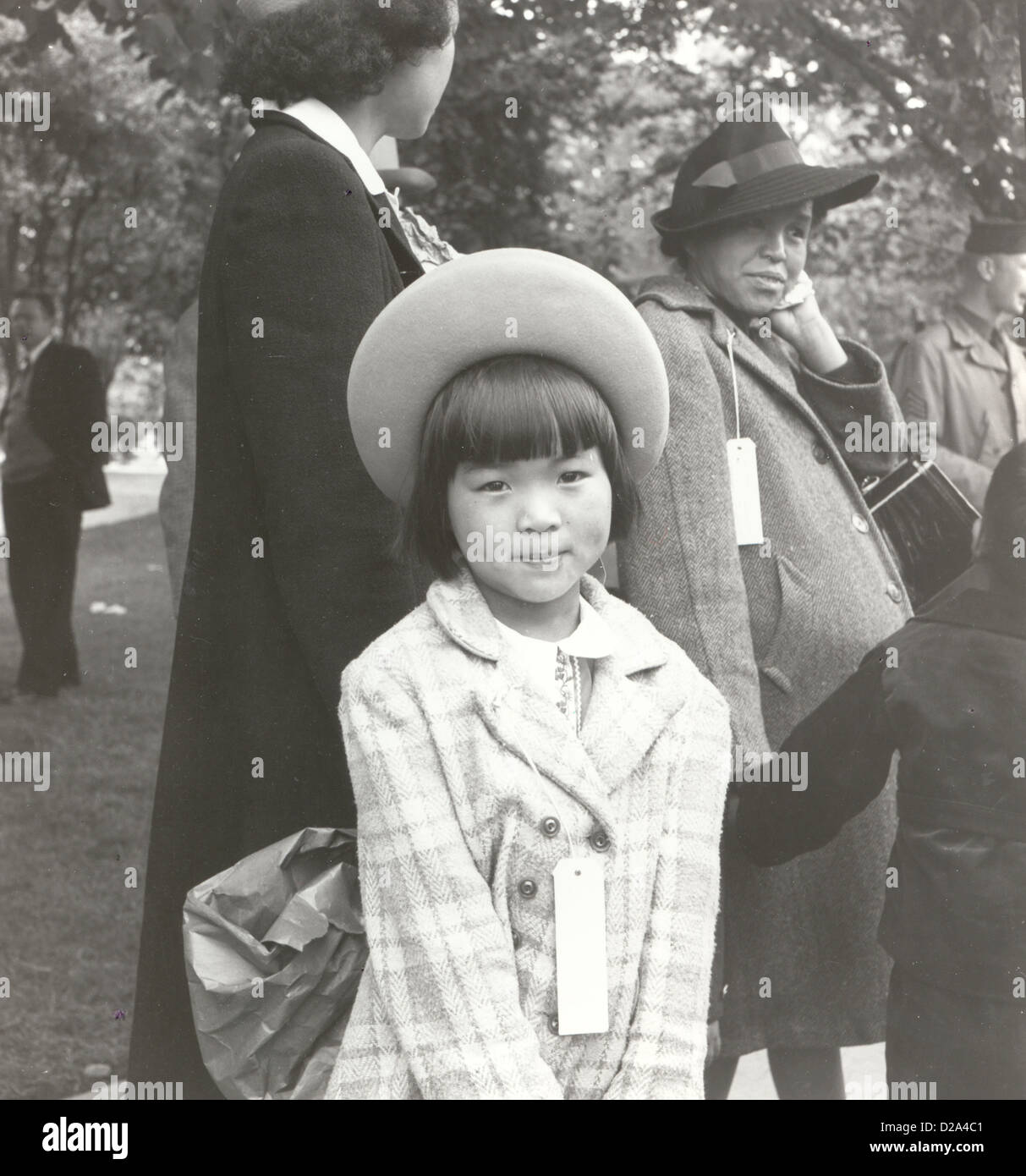 Hayward, California, joven miembro de la familia evacuada esperando el autobús de evacuación evacuados ascendencia japonesa se alojarán en guerra Foto de stock