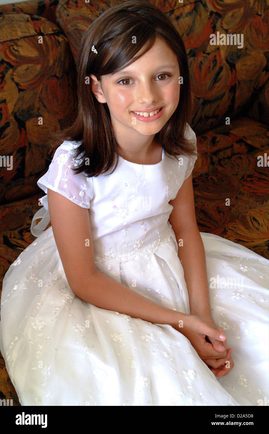 Chica en vestido blanco en el sofá Foto de stock