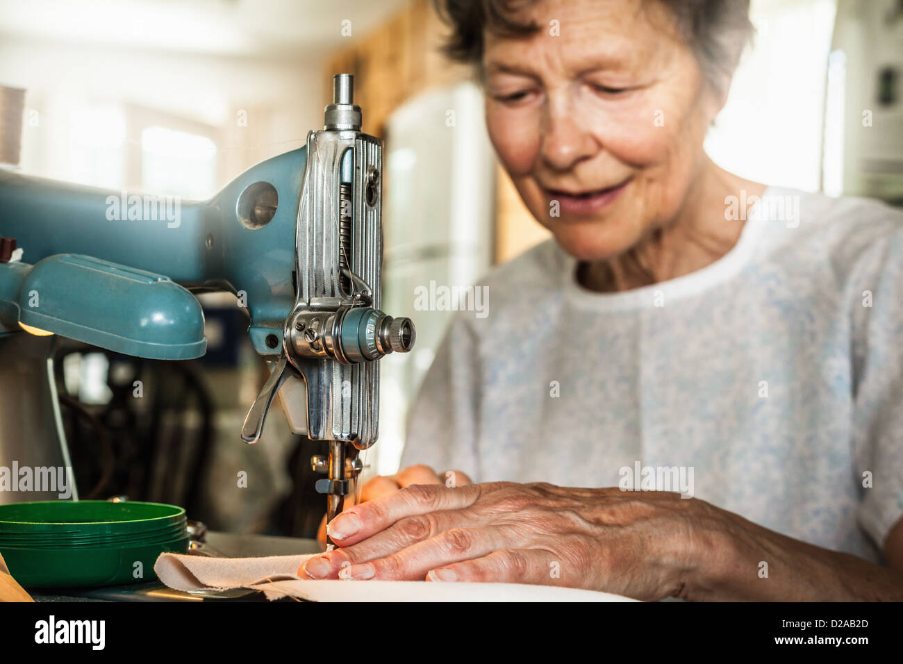 Mujer de edad trabajando en la máquina de coser Foto de stock