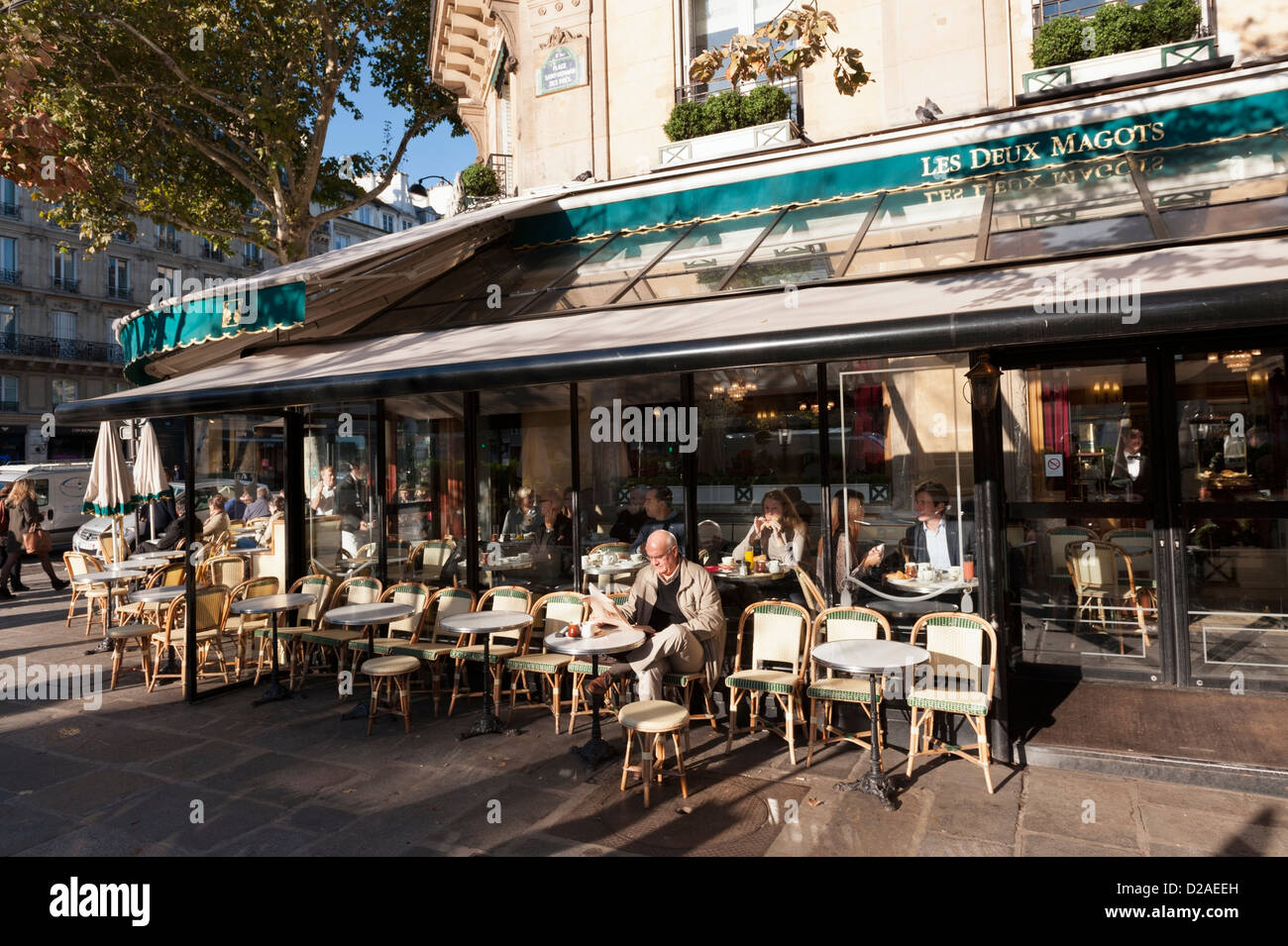 Los clientes en una soleada mañana de otoño en el famoso café parisino Les Deux Magots en Saint-Germain-des-Prés. Foto de stock