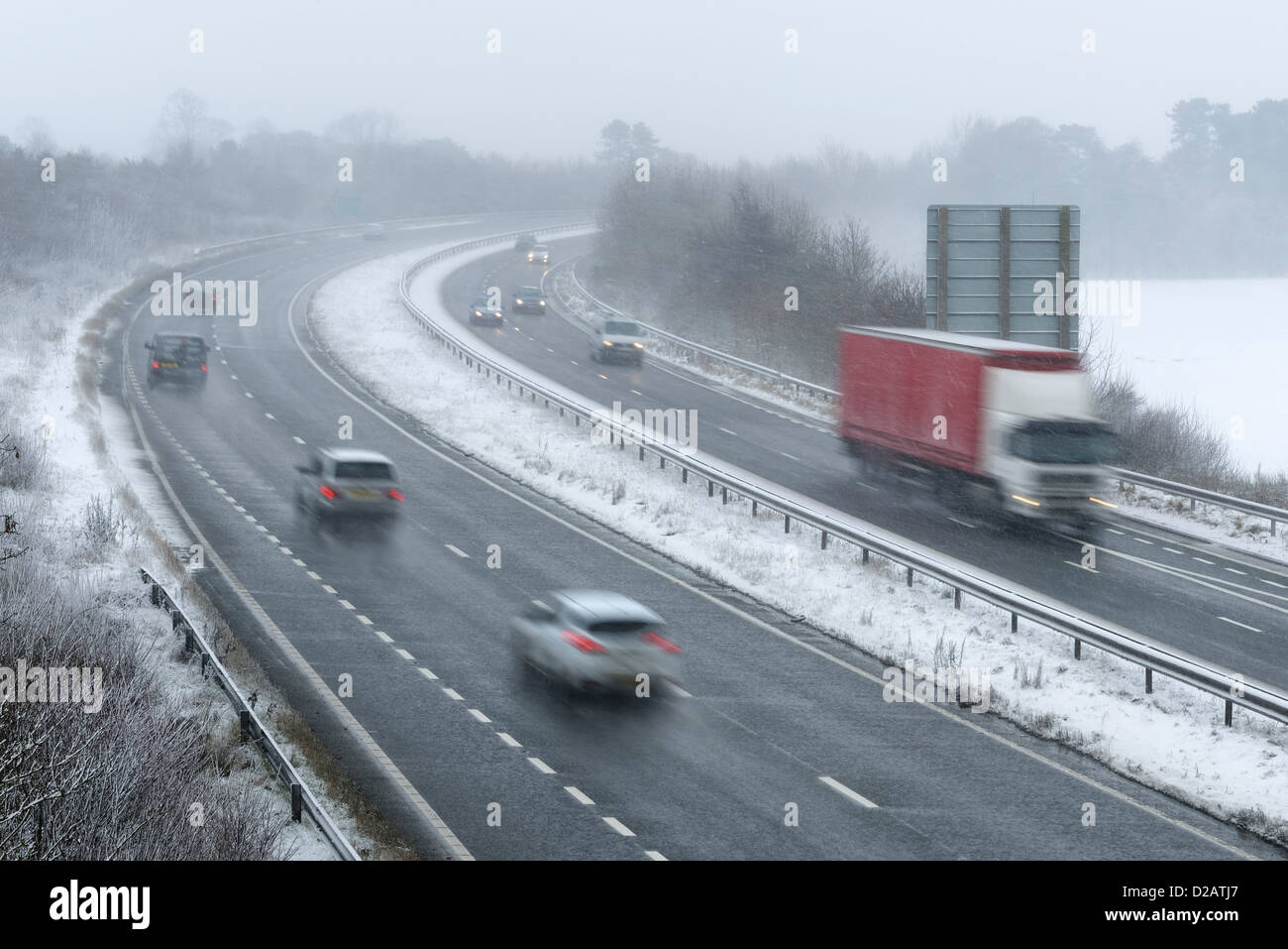 El tráfico que viaja a lo largo de la A55 Chester Bypass en condiciones climáticas de nieve. Foto de stock