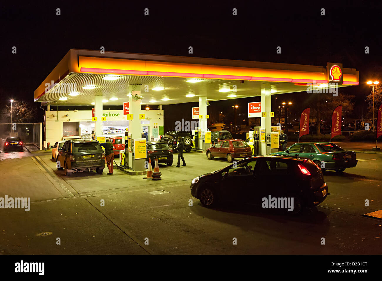 Estación de llenado de gasolina en el supermercado Waitrose durante la noche, Wales, REINO UNIDO Foto de stock