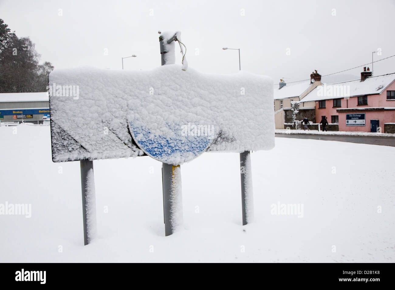 Señal de carretera, manténgase a la izquierda en la rotonda cubierto de nieve, Abergavenny, Wales, REINO UNIDO Foto de stock