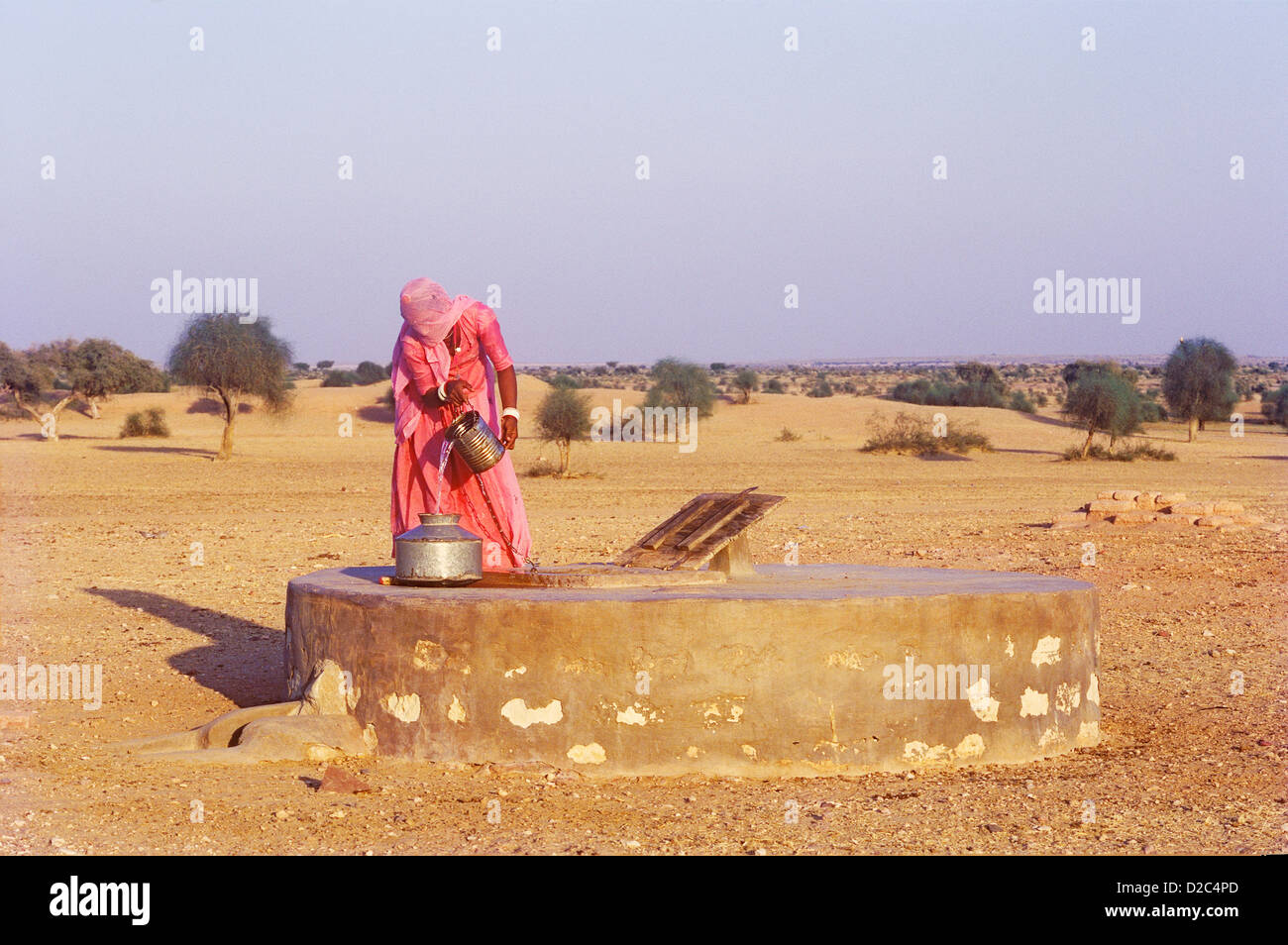 Mujer llena la olla de agua subterránea recogidas de apertura del tanque de recolección de agua de lluvia lateral izquierdo en la parte inferior del depósito permite la lluvia preciosos Foto de stock