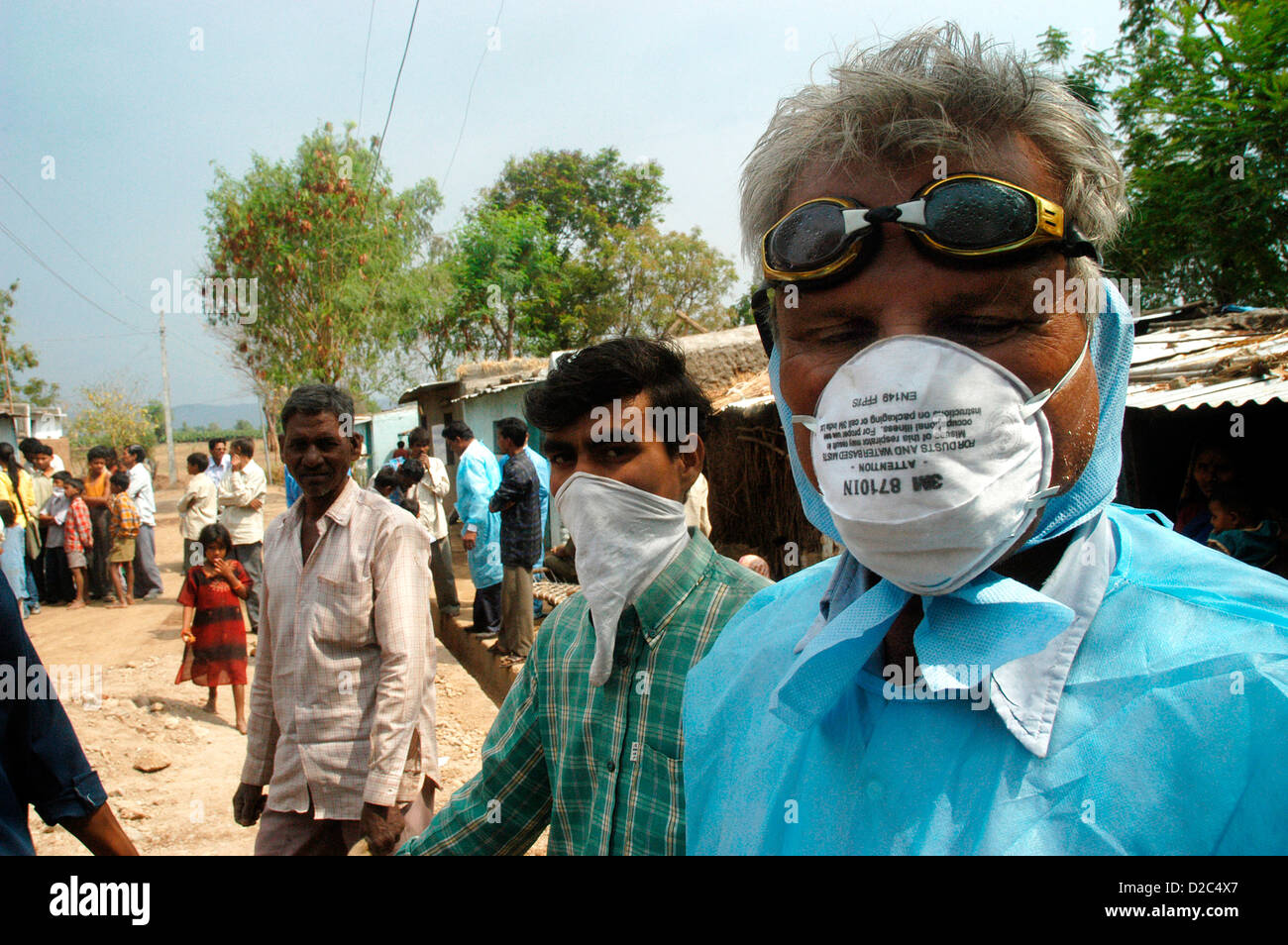Los trabajadores de salud cubren sus rostros máscaras protectoras, como ir de casa de sacrificio de los pollos infectados en las casas de los aldeanos de traspatio Foto de stock