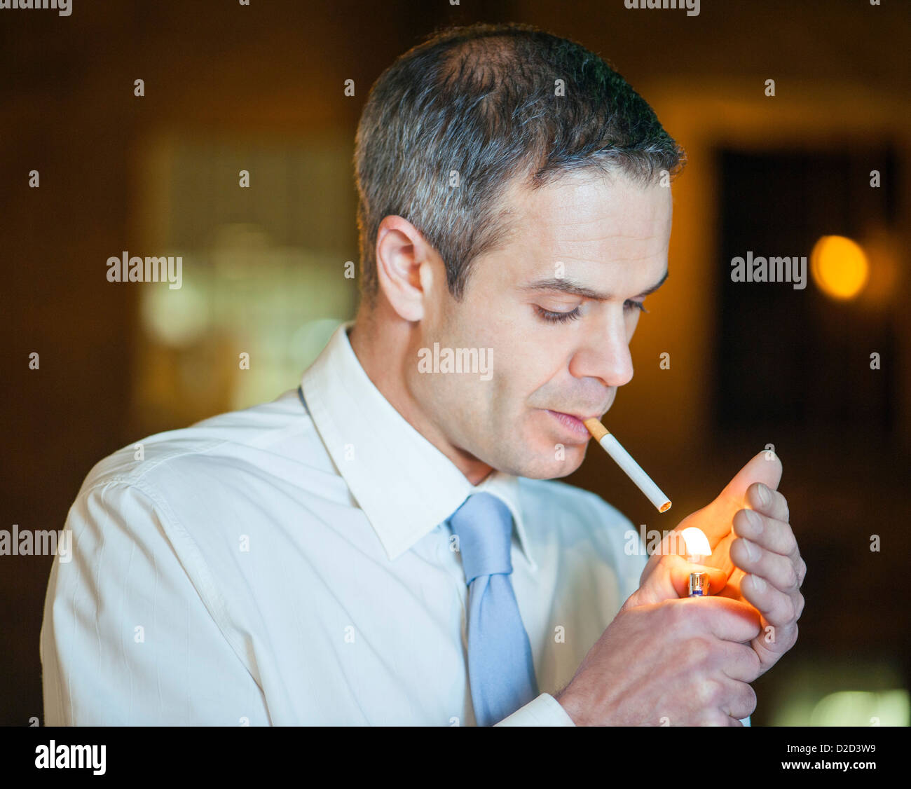 Modelo liberado el hombre enciende un cigarrillo Foto de stock