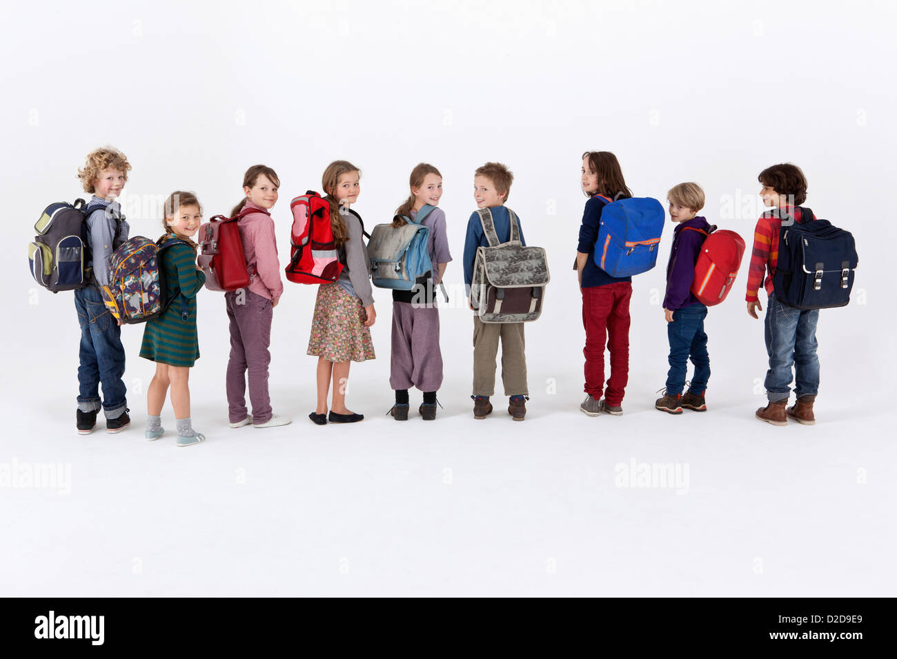 Una fila de niños escuela portando mochilas y parado en una fila Fotografía de stock - Alamy