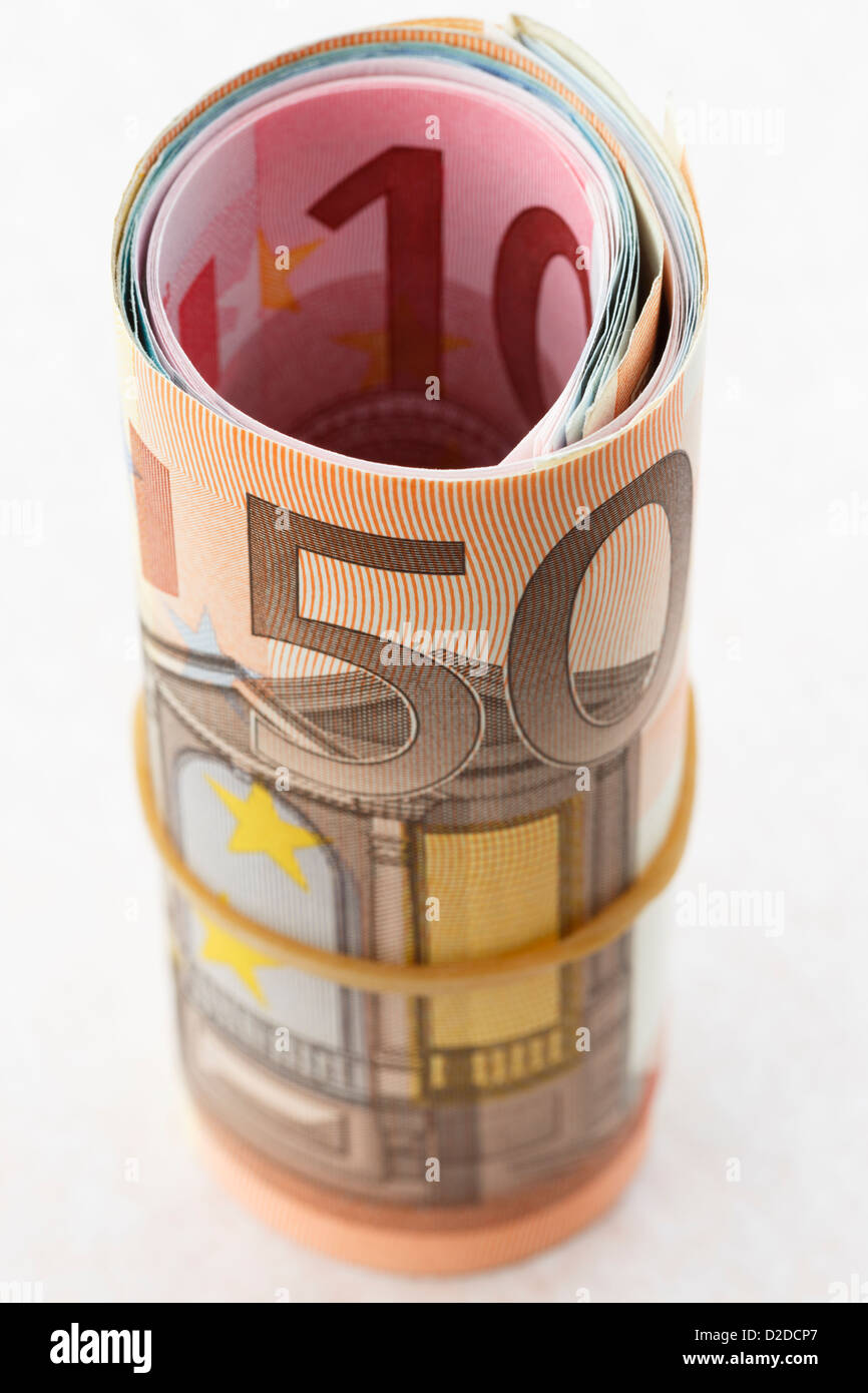 50 Euros nota sobre un rollo de dinero de Euros se enrolla con una banda elástica sobre un fondo blanco para ilustrar el concepto de ahorro de dinero. Europa Foto de stock