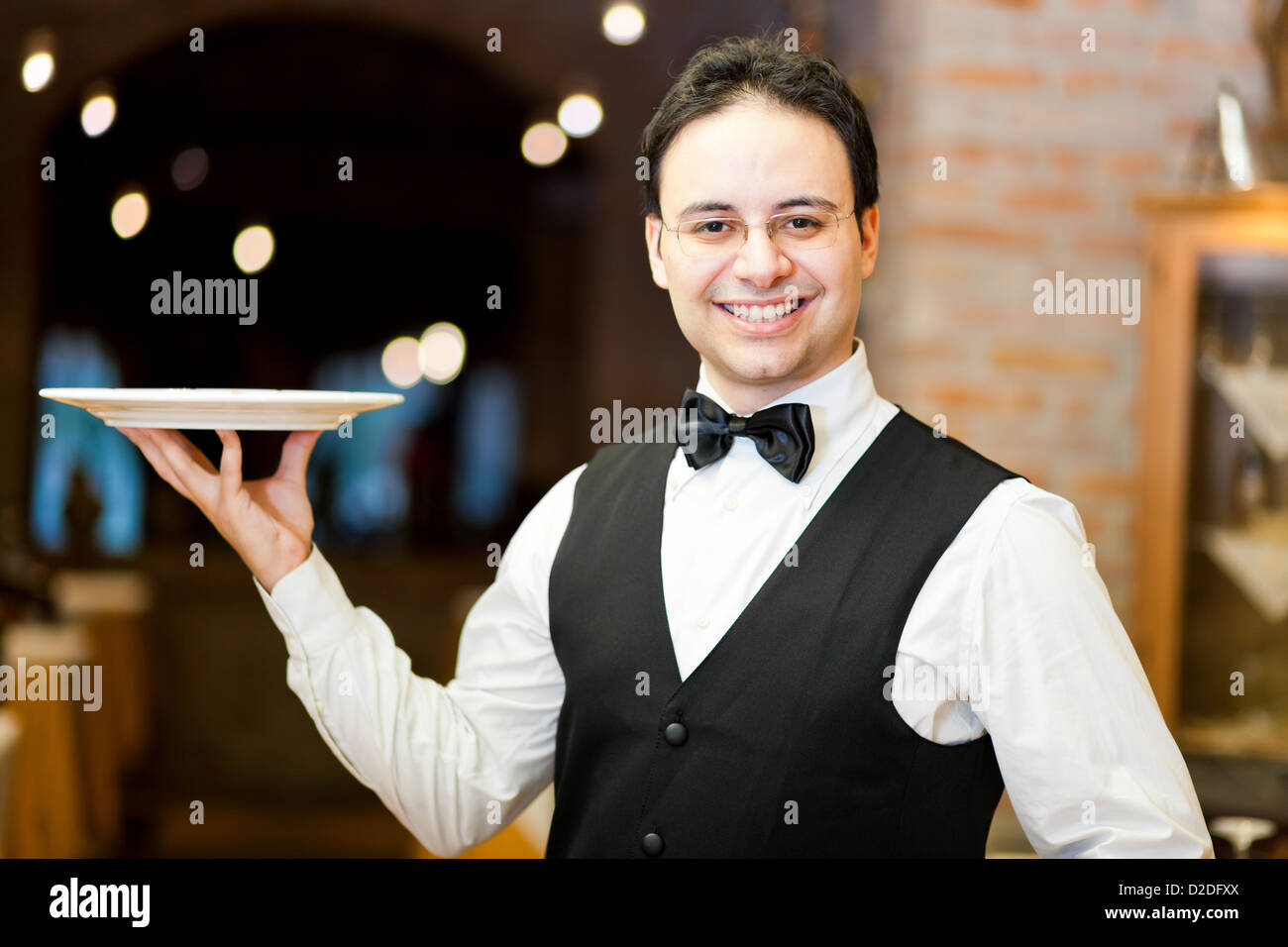 Camarero sosteniendo una placa Foto de stock