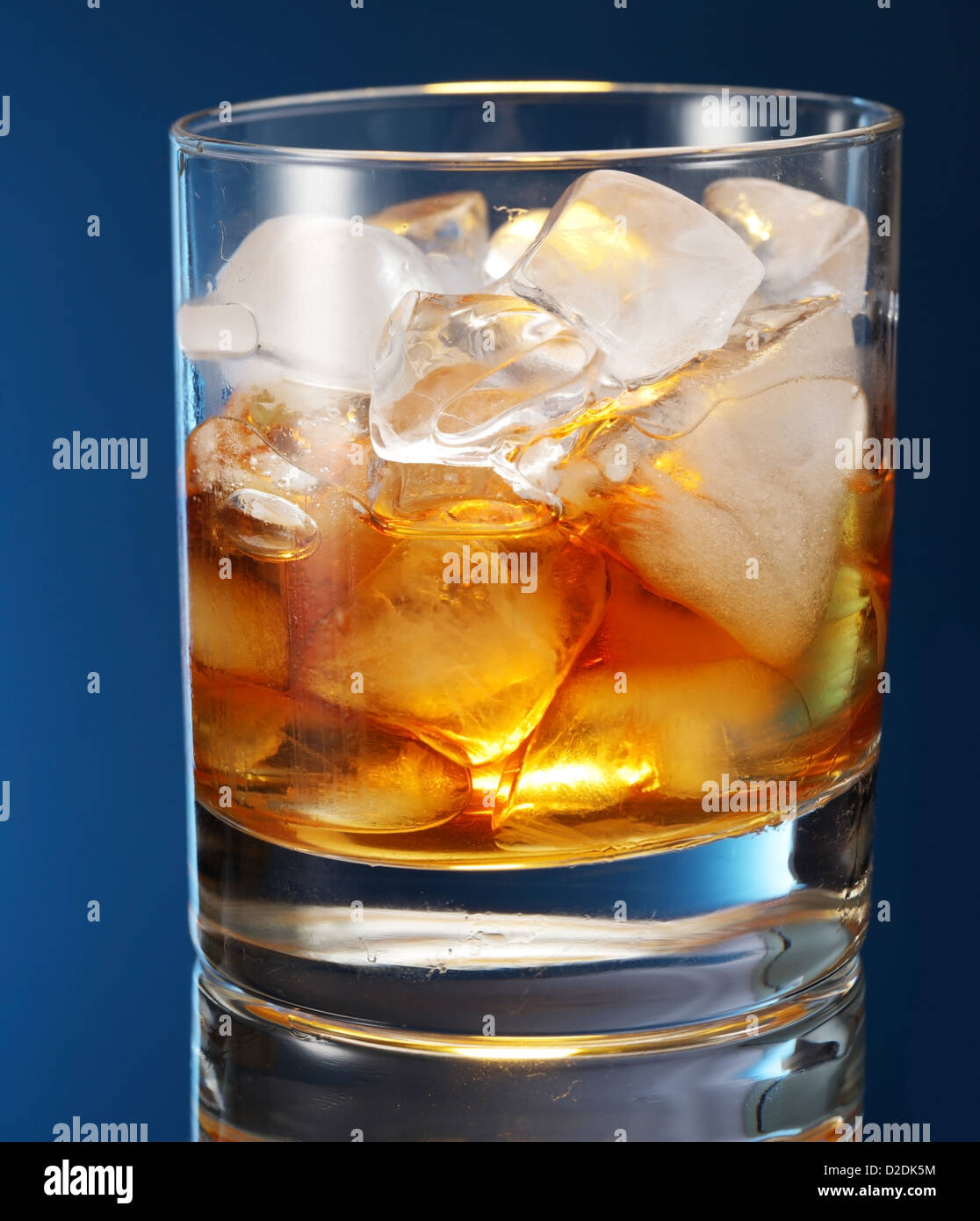 Vaso de whisky sobre un fondo azul. Foto de stock