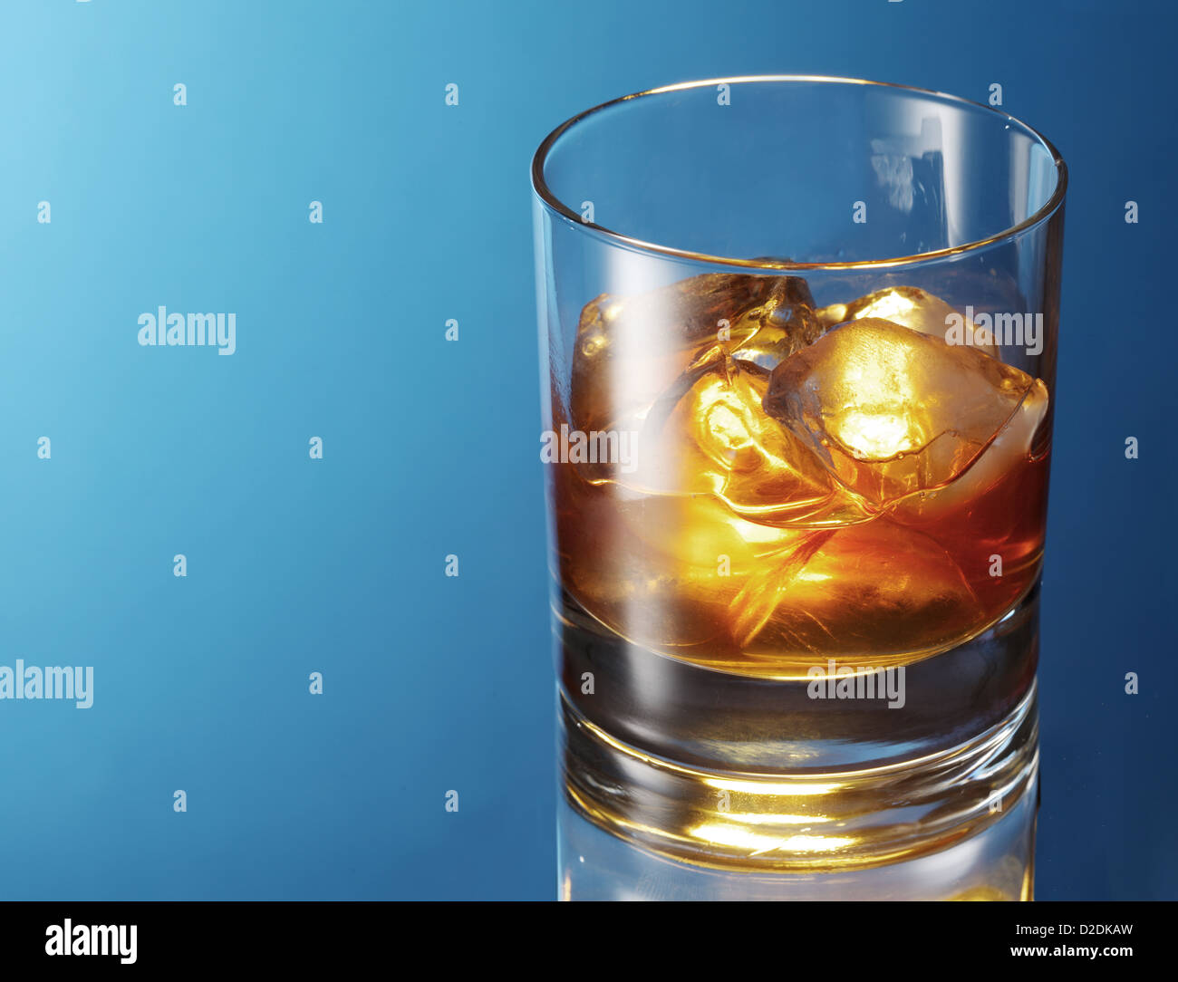 Vaso de whisky sobre un fondo azul. Foto de stock