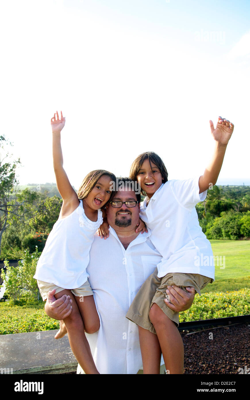 Un hombre sostiene su sobrino y sobrina. Foto de stock