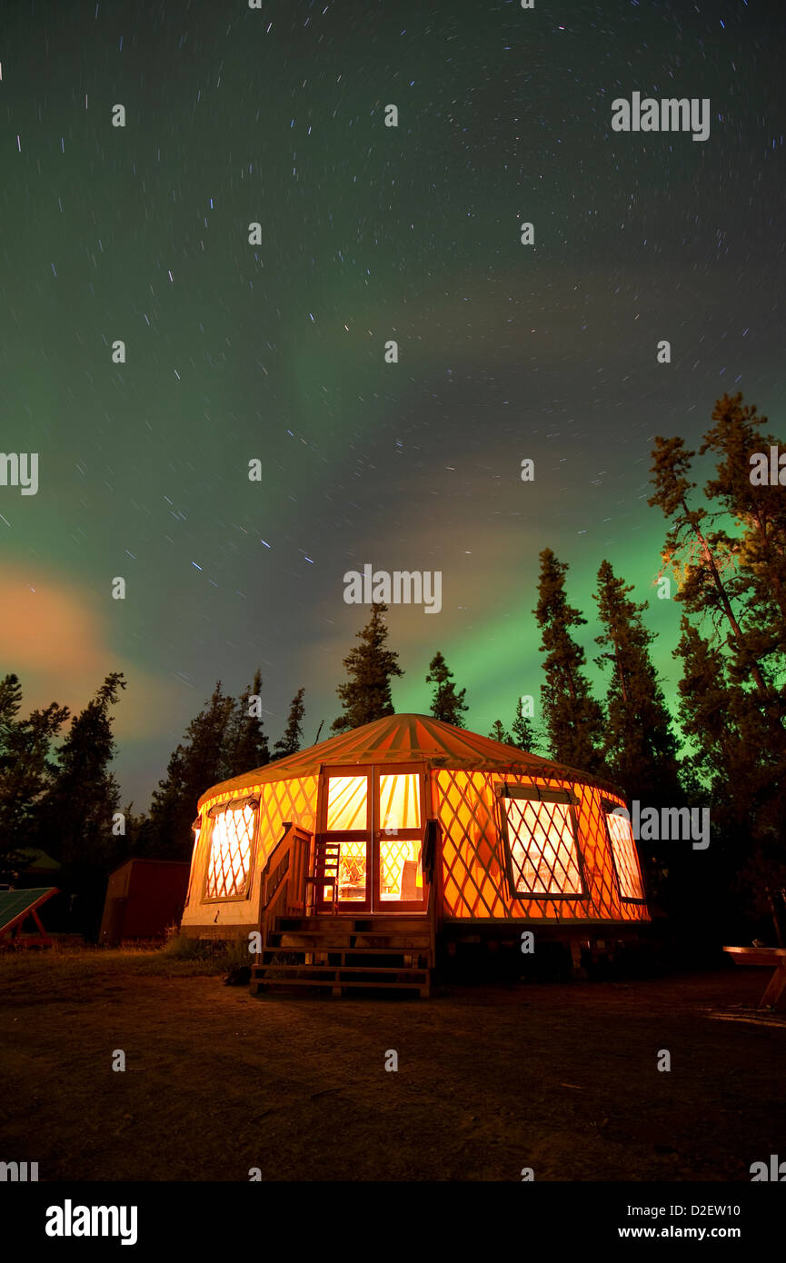 El Aurora Borealis (Luces del Norte) a través de una yurta iluminada fuera de Whitehorse en el territorio de Yukon, Canadá. Foto de stock