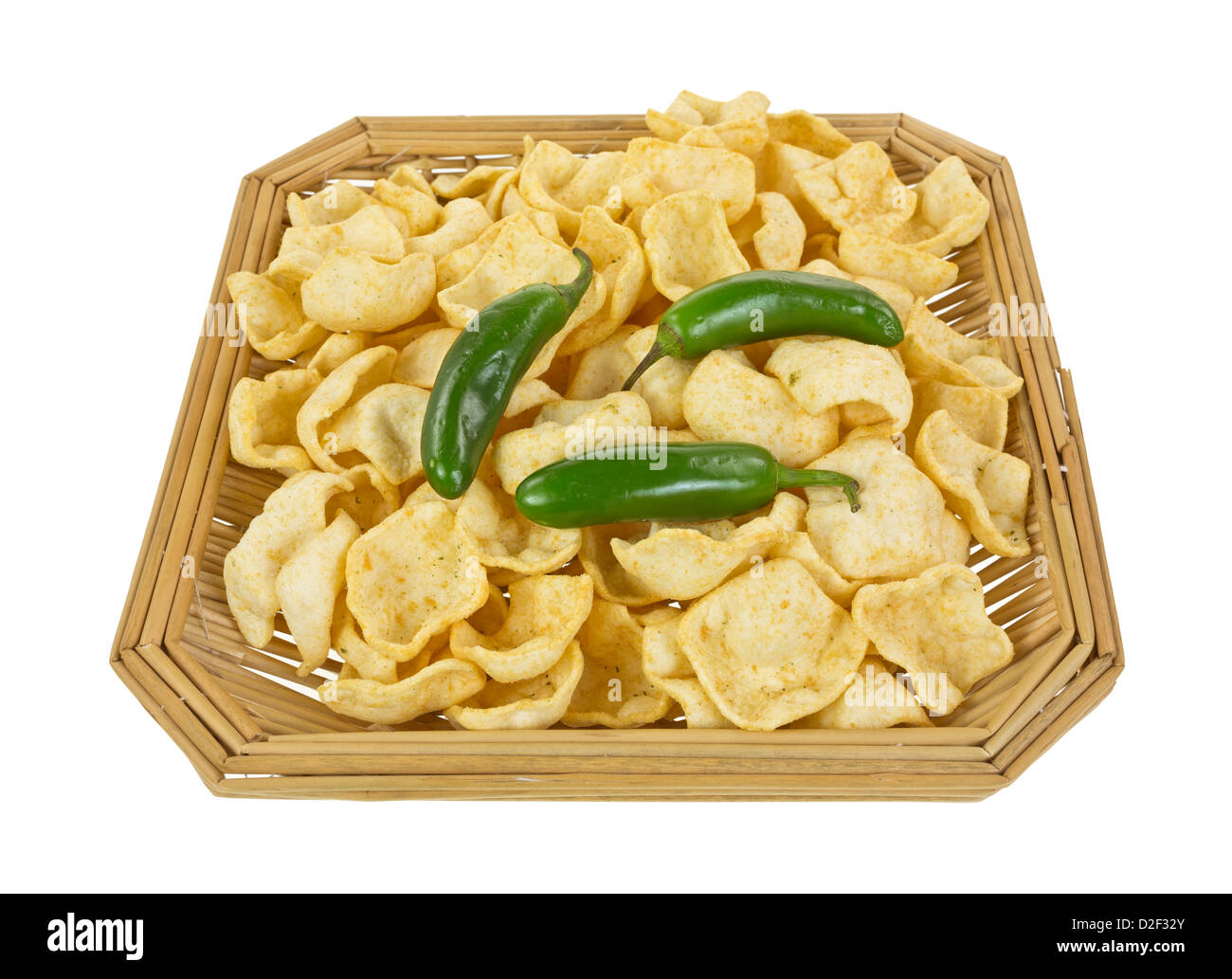 Un viejo cesto de mimbre llenas de jalapeño papas fritas sazonadas con tres chiles jalapeños enteros frescos en la parte superior. Foto de stock