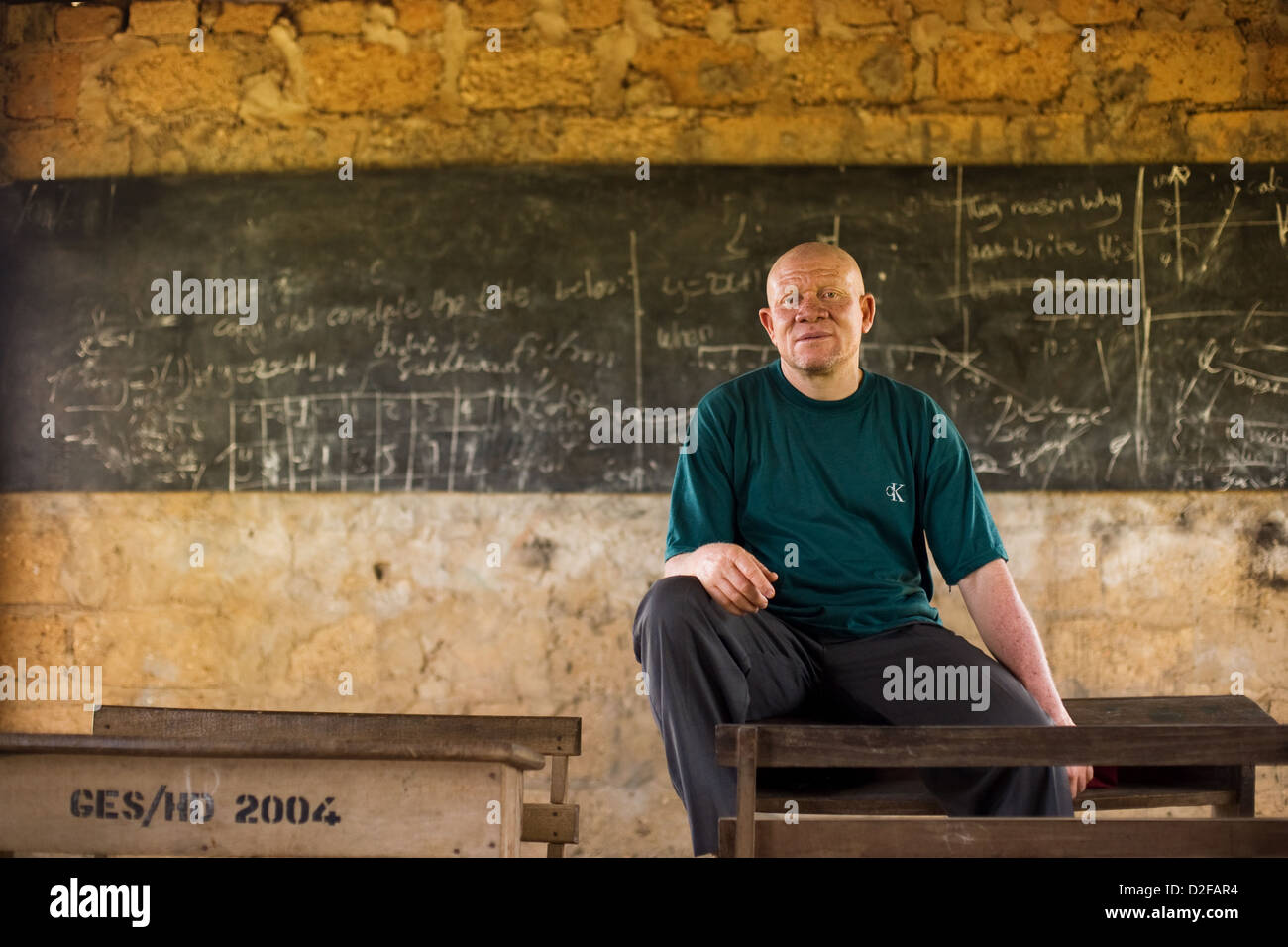 Retrato de un maestro de escuela albino africano en su aula. Foto de stock