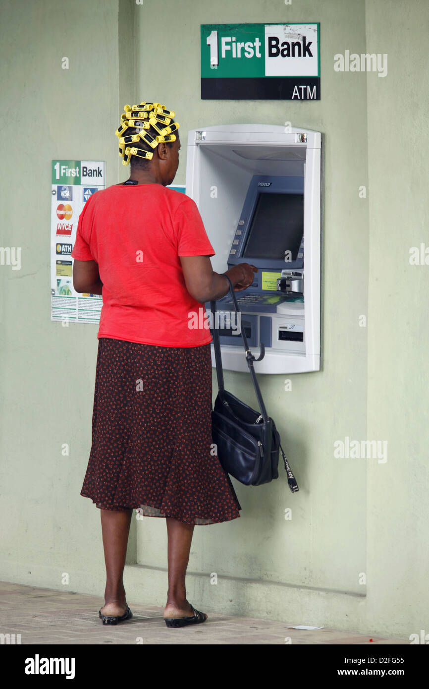 Mujer con rulos mediante cajero automático, Frederiksted, St. Croix, Islas Vírgenes de EE.UU., el Caribe Foto de stock
