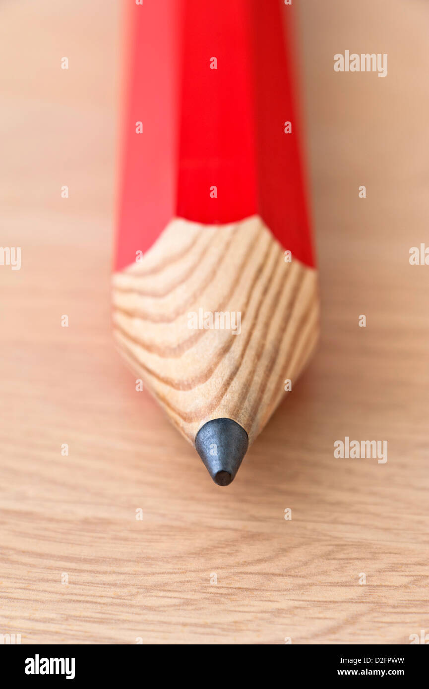 Cerrar detalle de la cabeza de un lápiz de color rojo sobre un fondo de madera Foto de stock