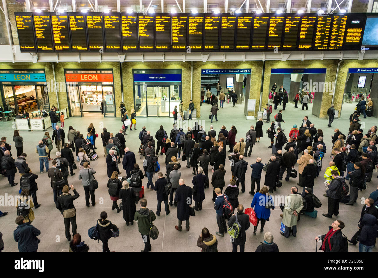 La gente en la estación Kings Cross, Londres, Reino Unido - mirando las salidas juntas en las tardes rush hour con trenes cancelados retrasado Foto de stock