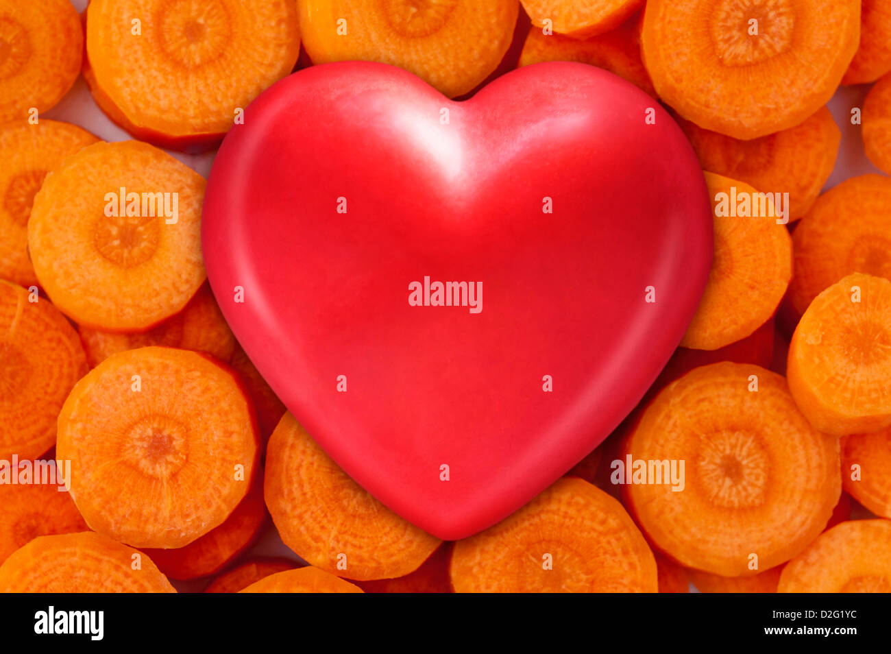 Alimentos saludables - corazón rojo sobre zanahorias frescas para comer sano Foto de stock