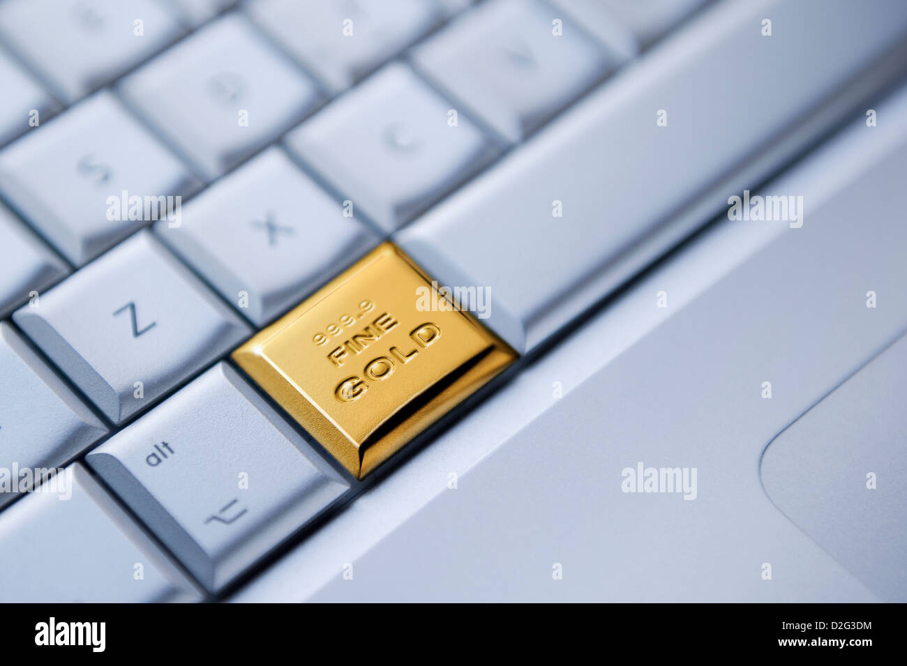 Detalle de un teclado con una tecla como una barra de oro macizo - online business / enriquecimiento / oro / existencias comerciales concepto Foto de stock
