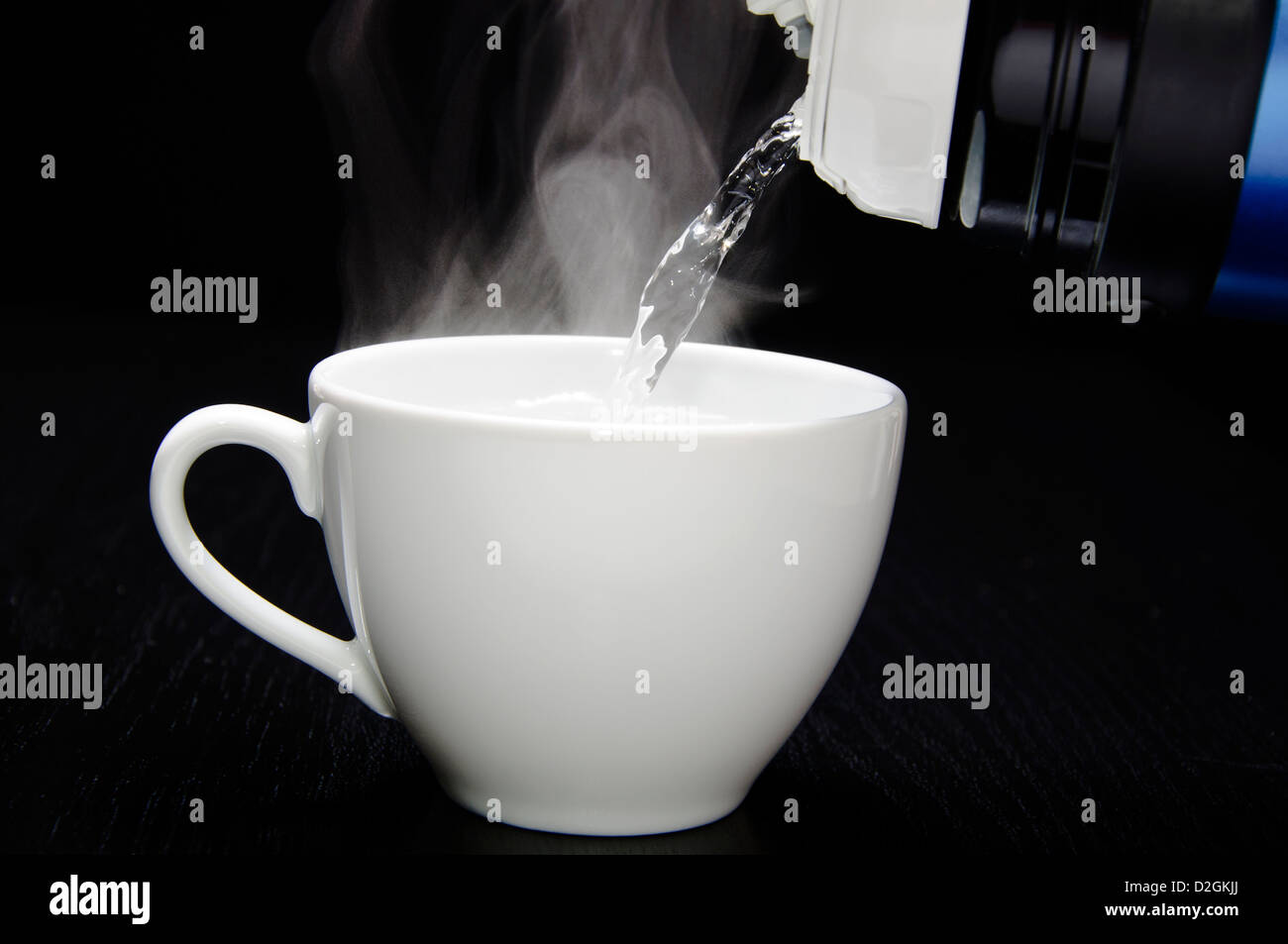 Verter el agua de la taza de té Foto de stock