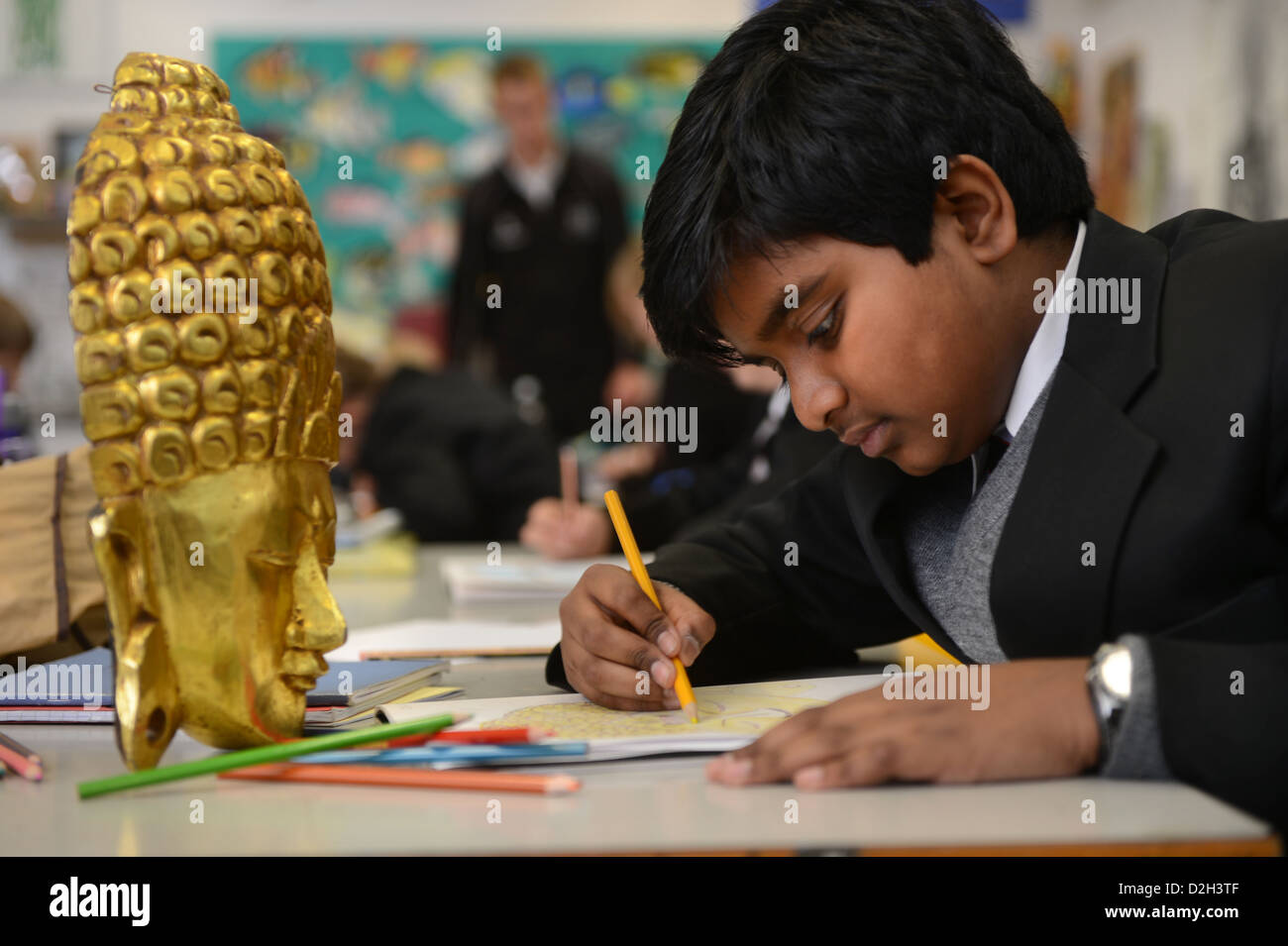 Un chico de once años dibujar una máscara en una lección de arte en la escuela de la Gramática de patés en Cheltenham, Gloucestershire, Reino Unido Foto de stock