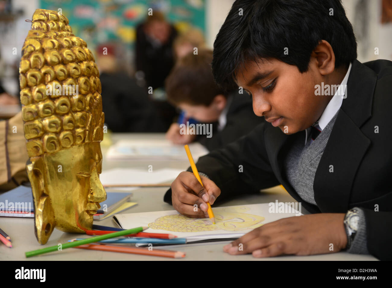 Un chico de once años dibujar una máscara en una lección de arte en la escuela de la Gramática de patés en Cheltenham, Gloucestershire, Reino Unido Foto de stock