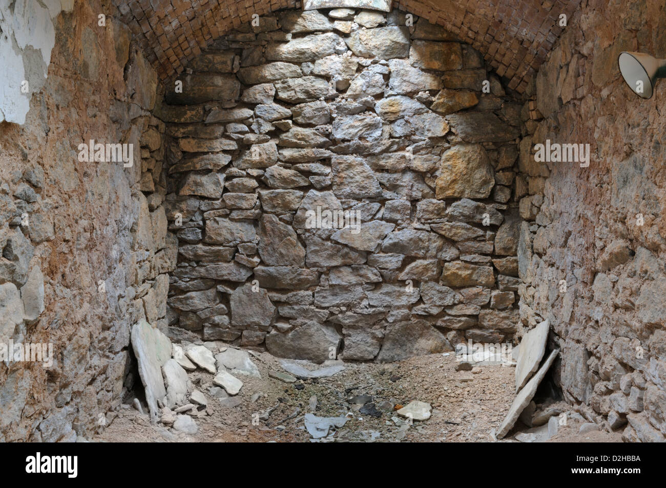 Celda de prisión pared de roca de piedra natural con lucernario superior, abandono y deterioro de la Penitenciaría del Estado del Este. Foto de stock
