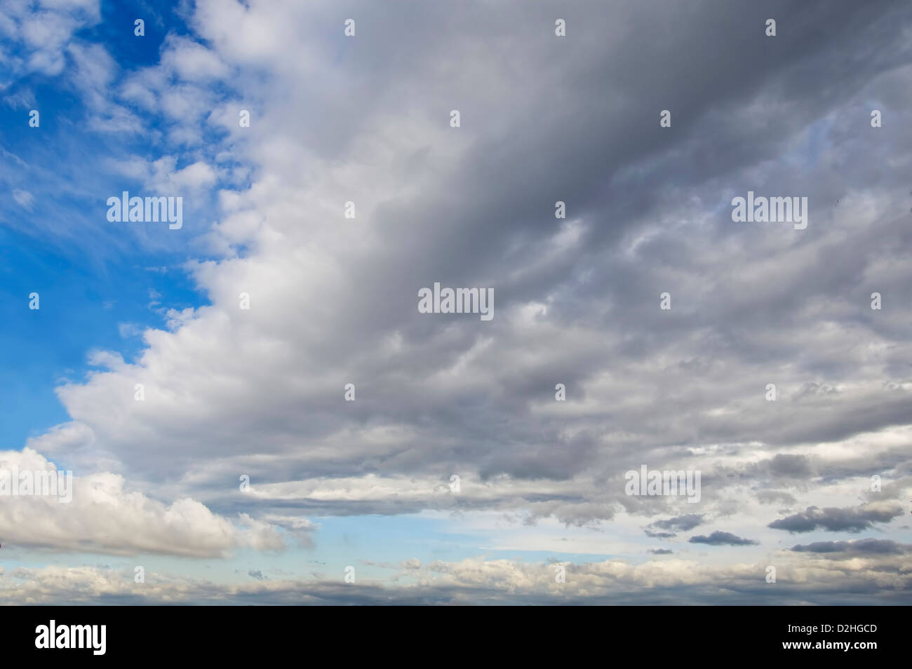 Cielo azul con nubes cúmulos de fondo y una gran nube delante. Foto de stock