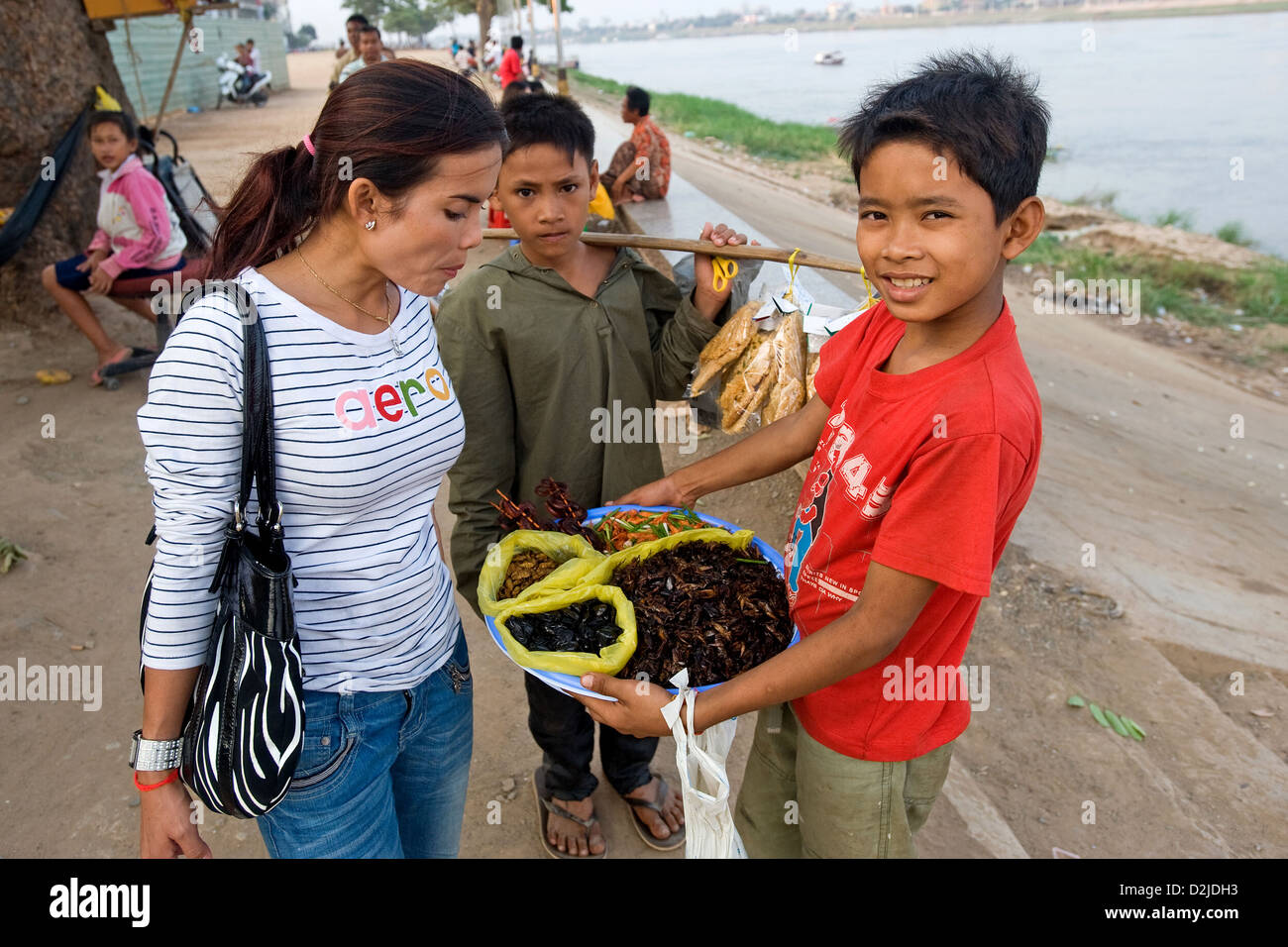 Phnom Penh, Camboya, una mujer examina el caparazón de un niño Foto de stock
