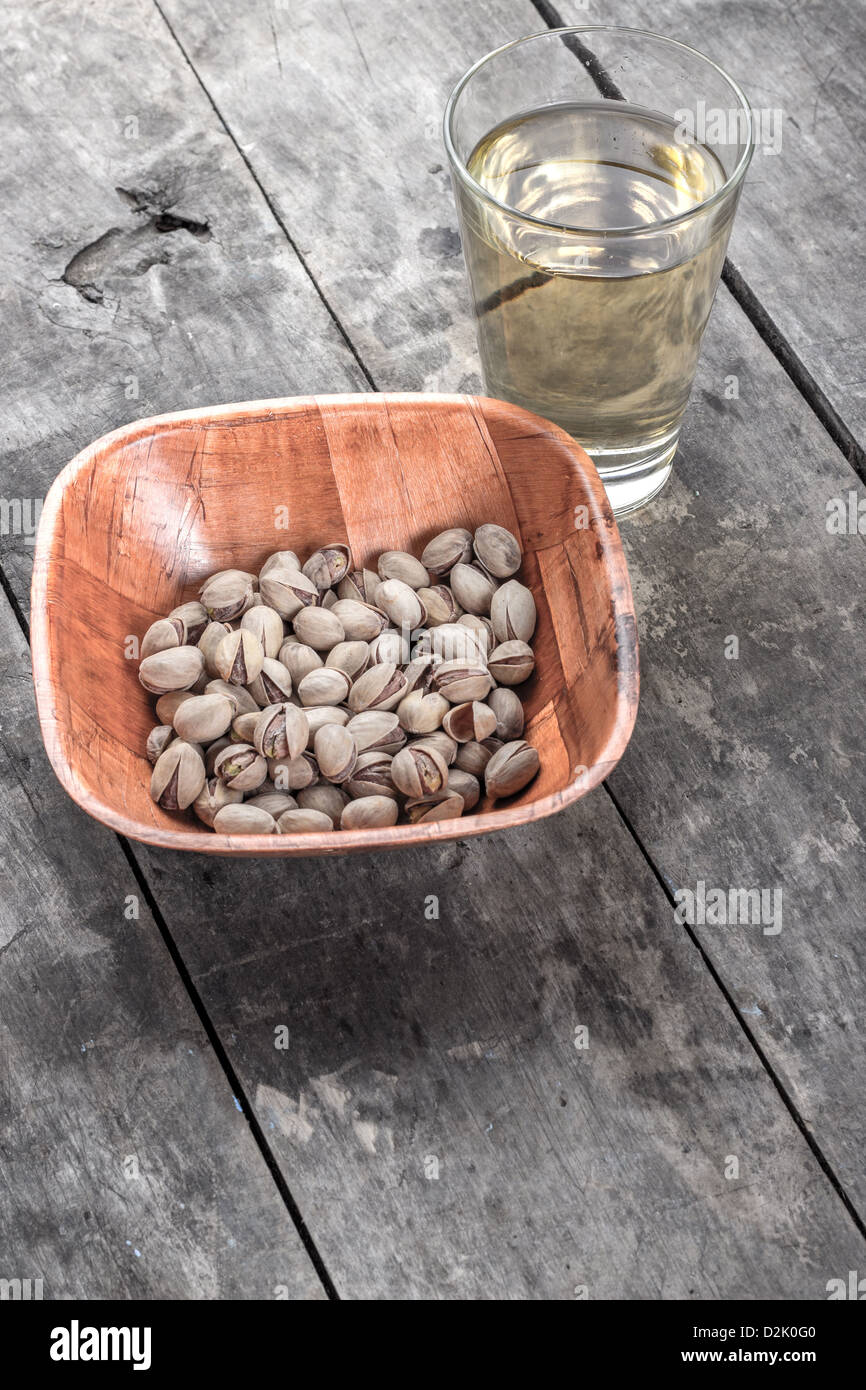 Los pistachos y el zumo de manzana sobre la mesa de madera Foto de stock