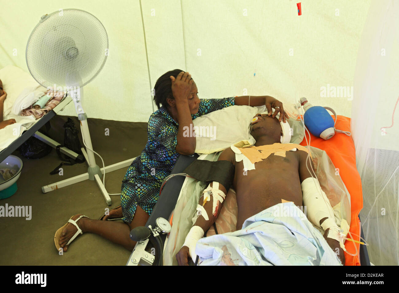Carrefour, Haití, arrodillado junto a un familiares heridos en la unidad de cuidados intensivos Foto de stock