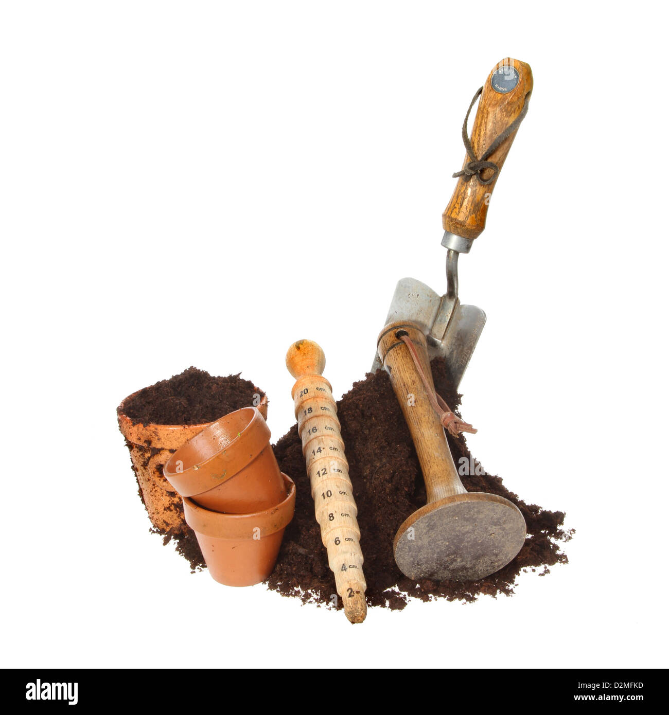 Las herramientas de jardín y macetas de terracota con un montón de tierra aislado contra un blanco Foto de stock