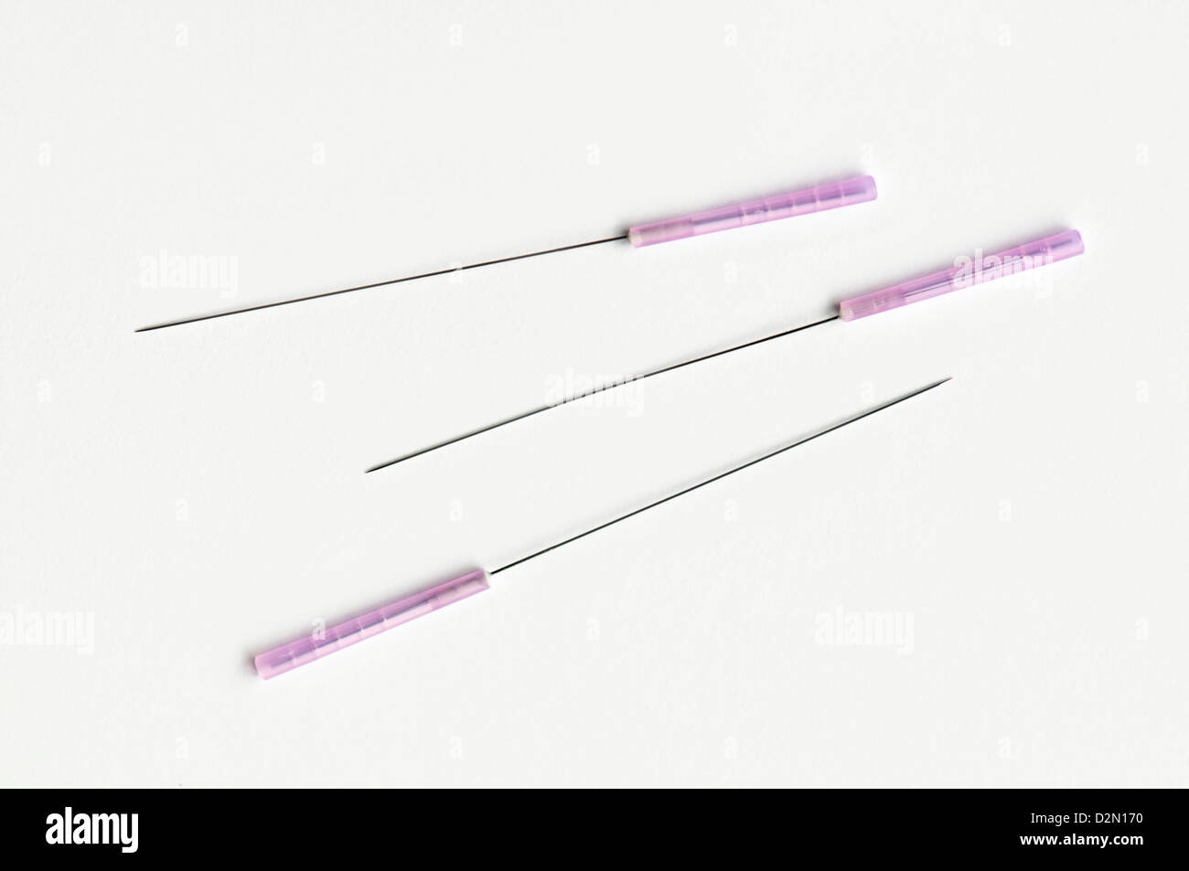 Cerca de tres abras de 1.5 pulgadas de tamaño de agujas de acupuntura tomadas contra un fondo completamente blanco Foto de stock