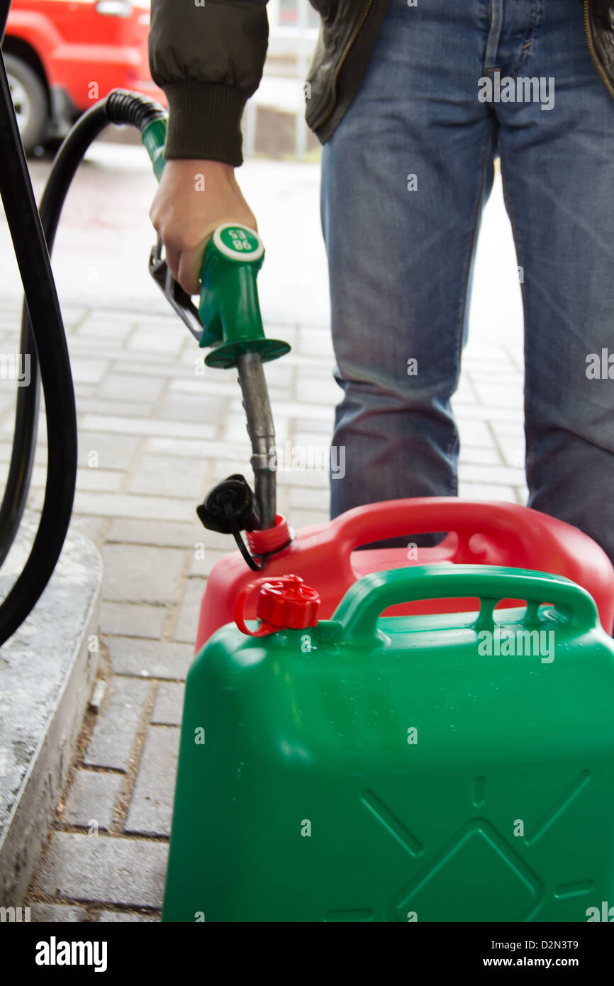 Hombre en jeans de gas en una estación de gasolina de plástico  deshidratante 98E Fotografía de stock - Alamy