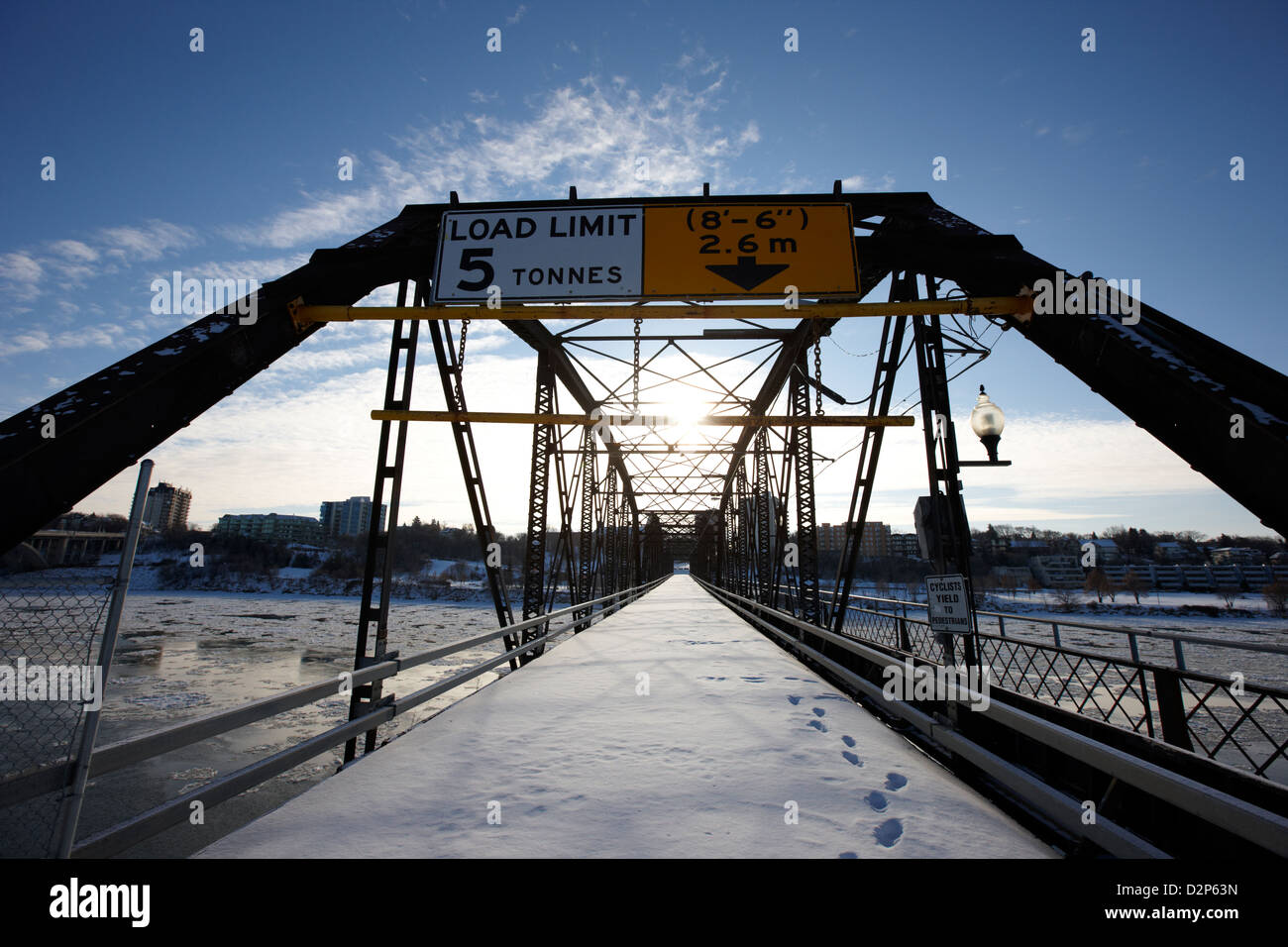 Tráfico el viejo puente sobre el río Saskatchewan del sur en invierno que fluye a través del centro de la ciudad de Saskatoon Saskatchewan Canadá Foto de stock