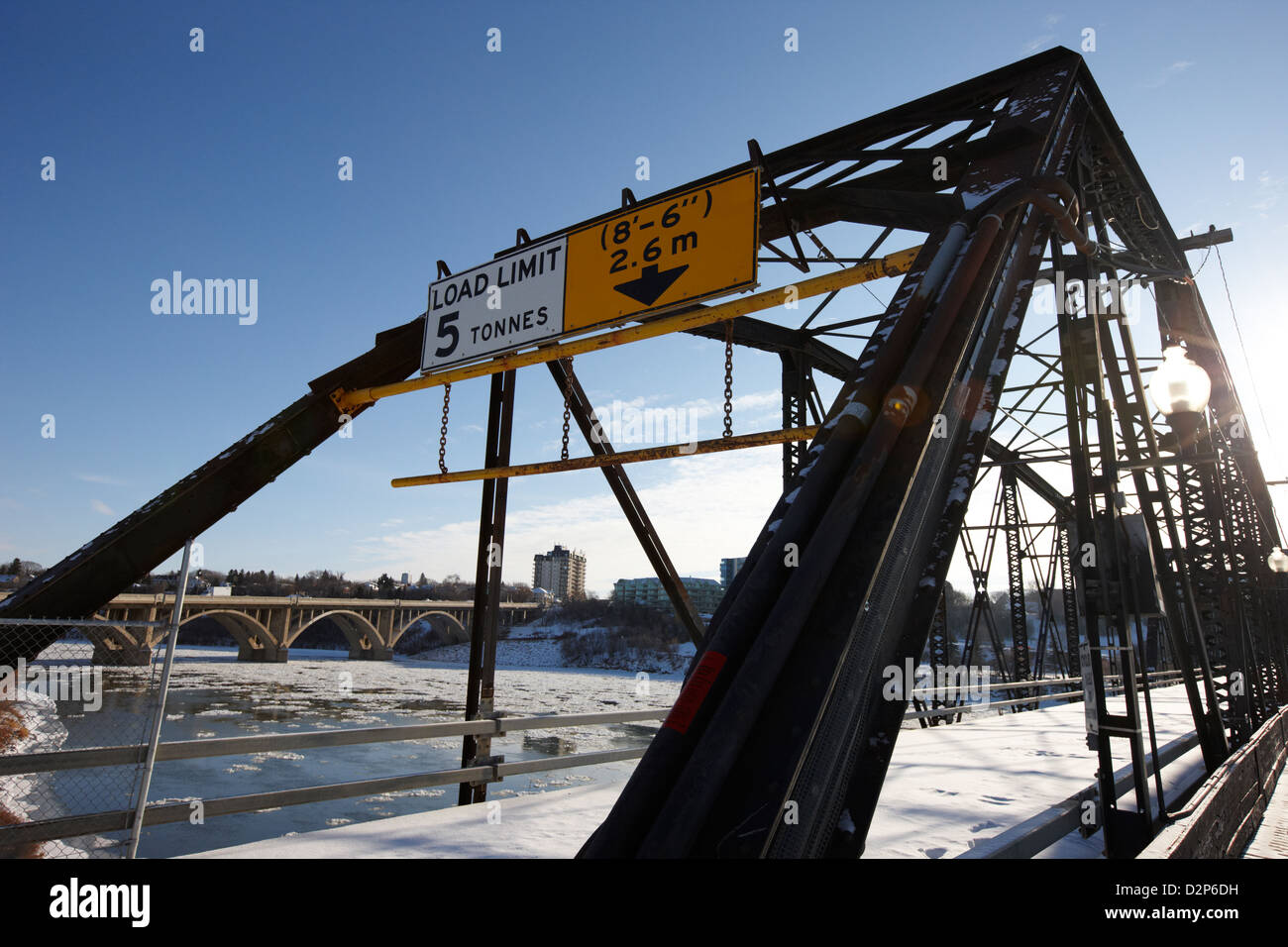 Tráfico el viejo puente sobre el río Saskatchewan del sur en invierno que fluye a través del centro de la ciudad de Saskatoon Saskatchewan Canadá Foto de stock