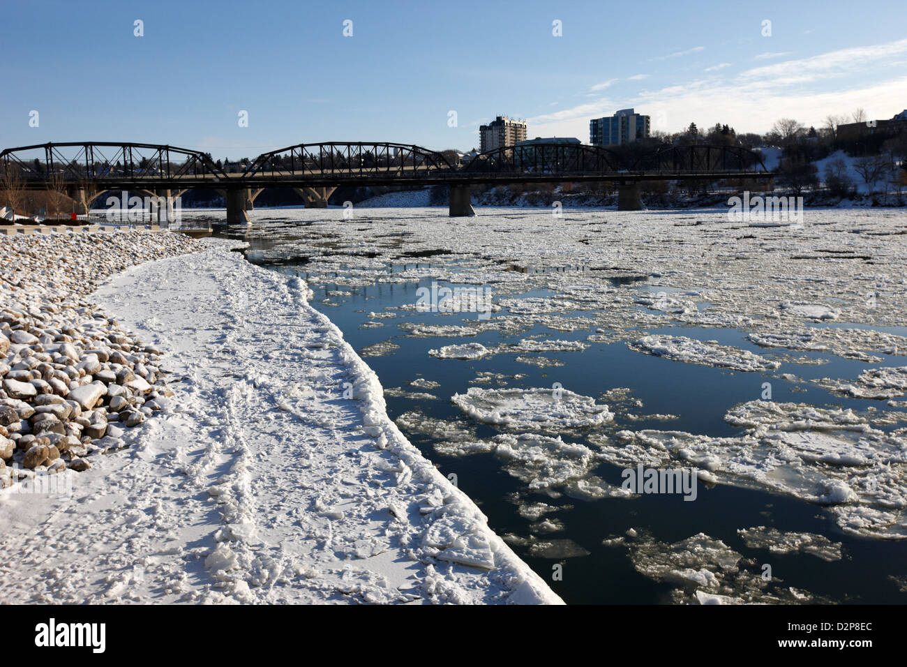 Grandes trozos de hielo flotante a orillas del río Saskatchewan del sur en invierno que fluye a través del centro de la ciudad de Saskatoon Saskatchewan Canadá Foto de stock