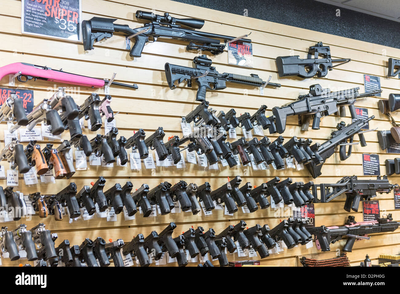Una gran variedad de pistolas, rifles y armas en un almacén de la pistola. Foto de stock