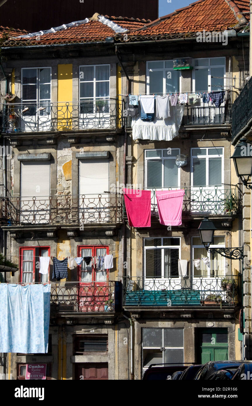Pisos en una calle residencial tradicional con balcones de hierro forjado, lavado colgar hacia fuera en el sol, Oporto, Portugal Foto de stock